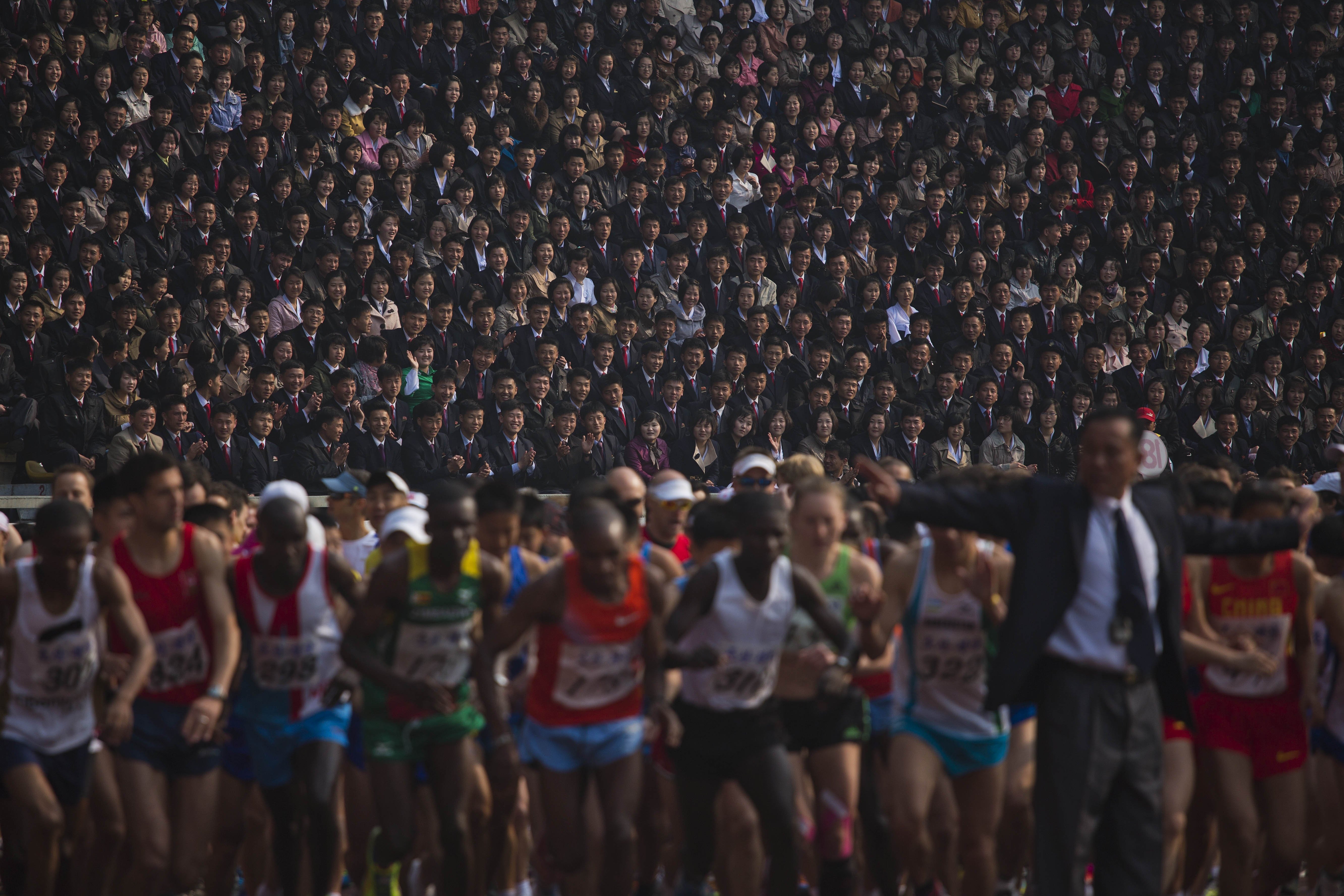 Apr. 13, 2014. North Korean spectators watch from the stands of Kim Il Sung Stadium as runners line up a the start of the Mangyongdae Prize International Marathon in Pyongyang, North Korea. The annual race was open to foreign tourists for the first time this year.