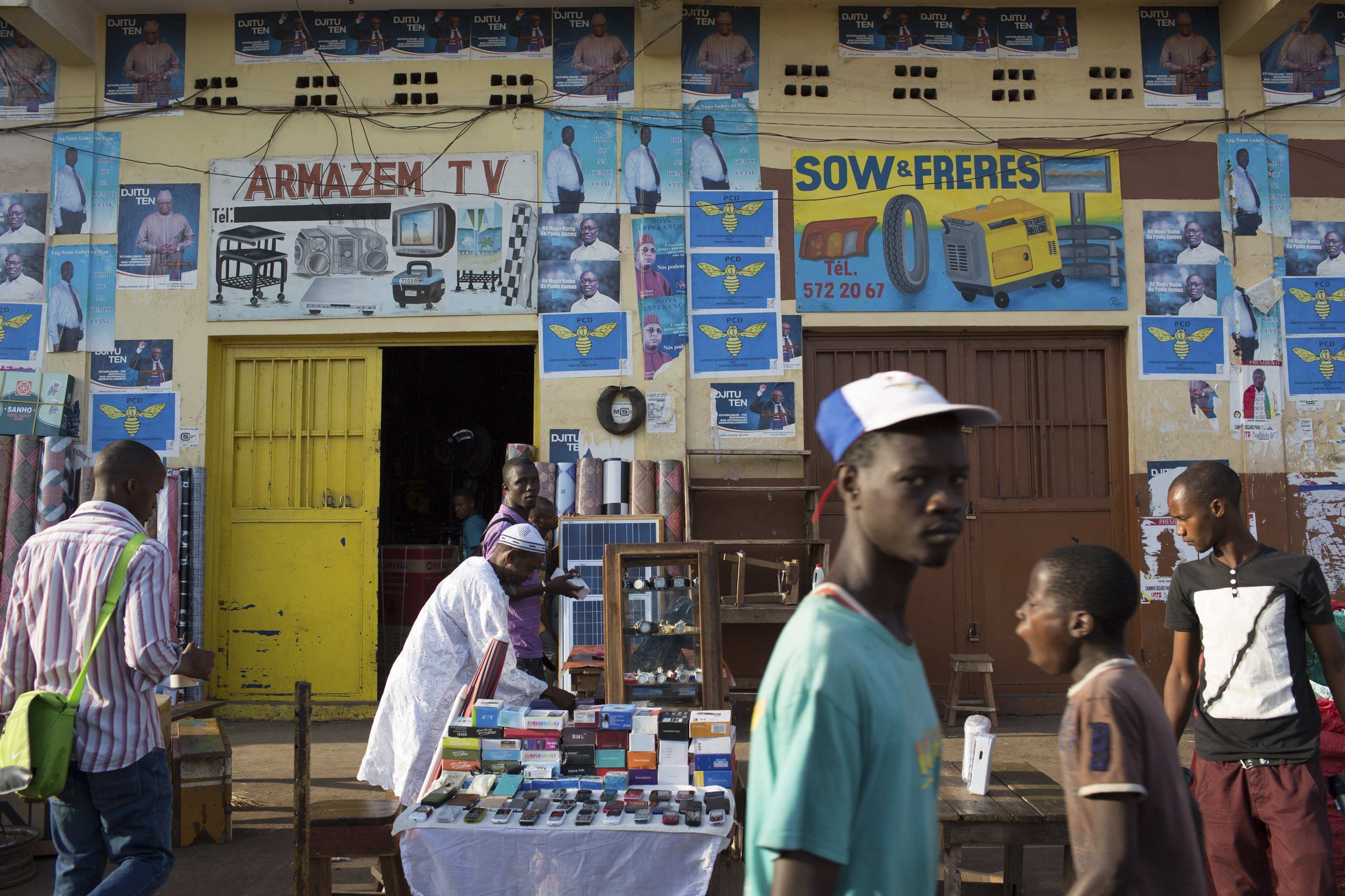 Apr. 11, 2014. People walk in front of presidential campaign posters in Bissau. Guinea-Bissau, one of the world's poorest countries, will go the polls on Sunday in a long-delayed legislative and presidential election intended to draw a line under a 2012 military coup.