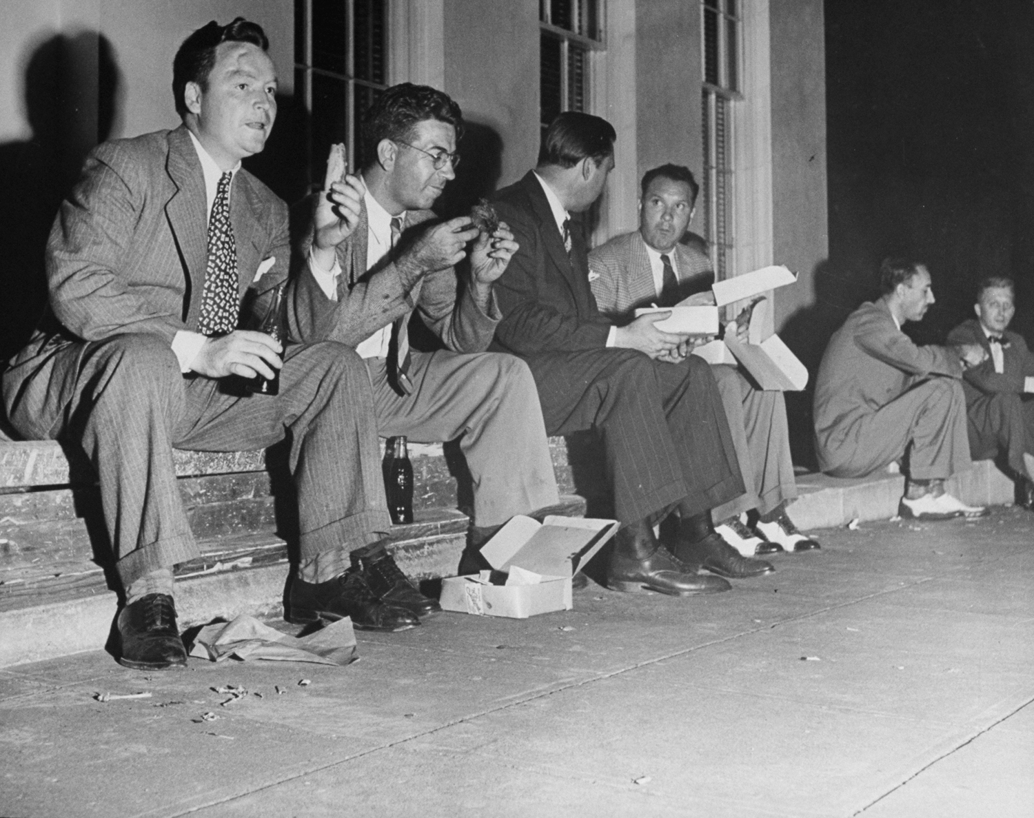 Newsmen eat while wait for news on Japan's acceptance of surrender terms, Washington, 1945.