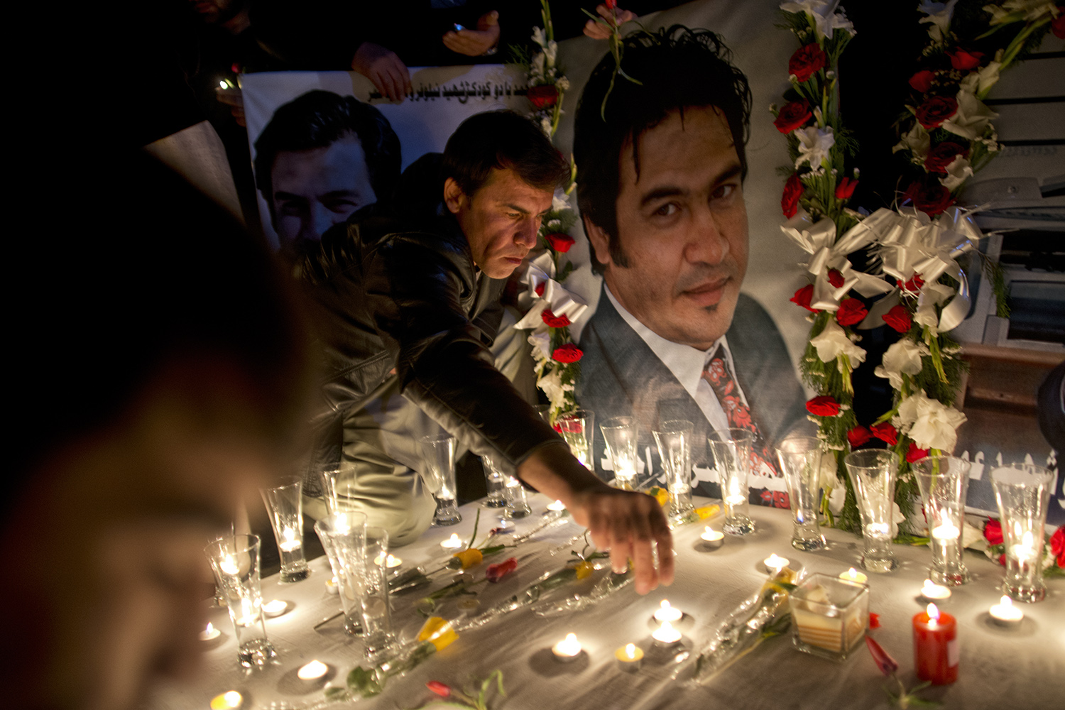 Friends, colleagues, and relatives  hold a vigil in  honor of slain Agence France Press correspondent Sardar Ahmad, his wife, and two of their three children in Kabul, Afghanistan, March 26, 2014.