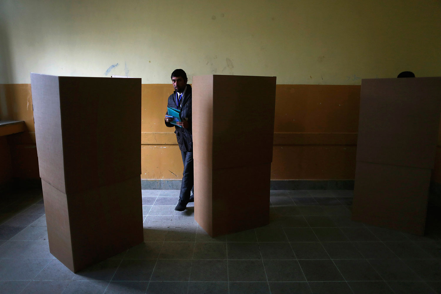 An Afghan man walks from a voting booth after completing his ballot paper at a polling station in Kabul.