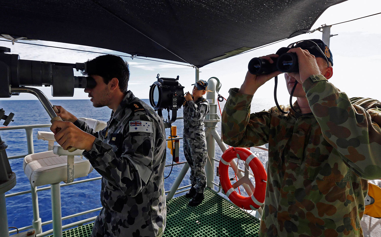 Crewmen aboard the Australian Navy ship HMAS Perth look towards the HMAS Success during manoeuvres as they continue to search for missing Malaysian Airlines flight MH370