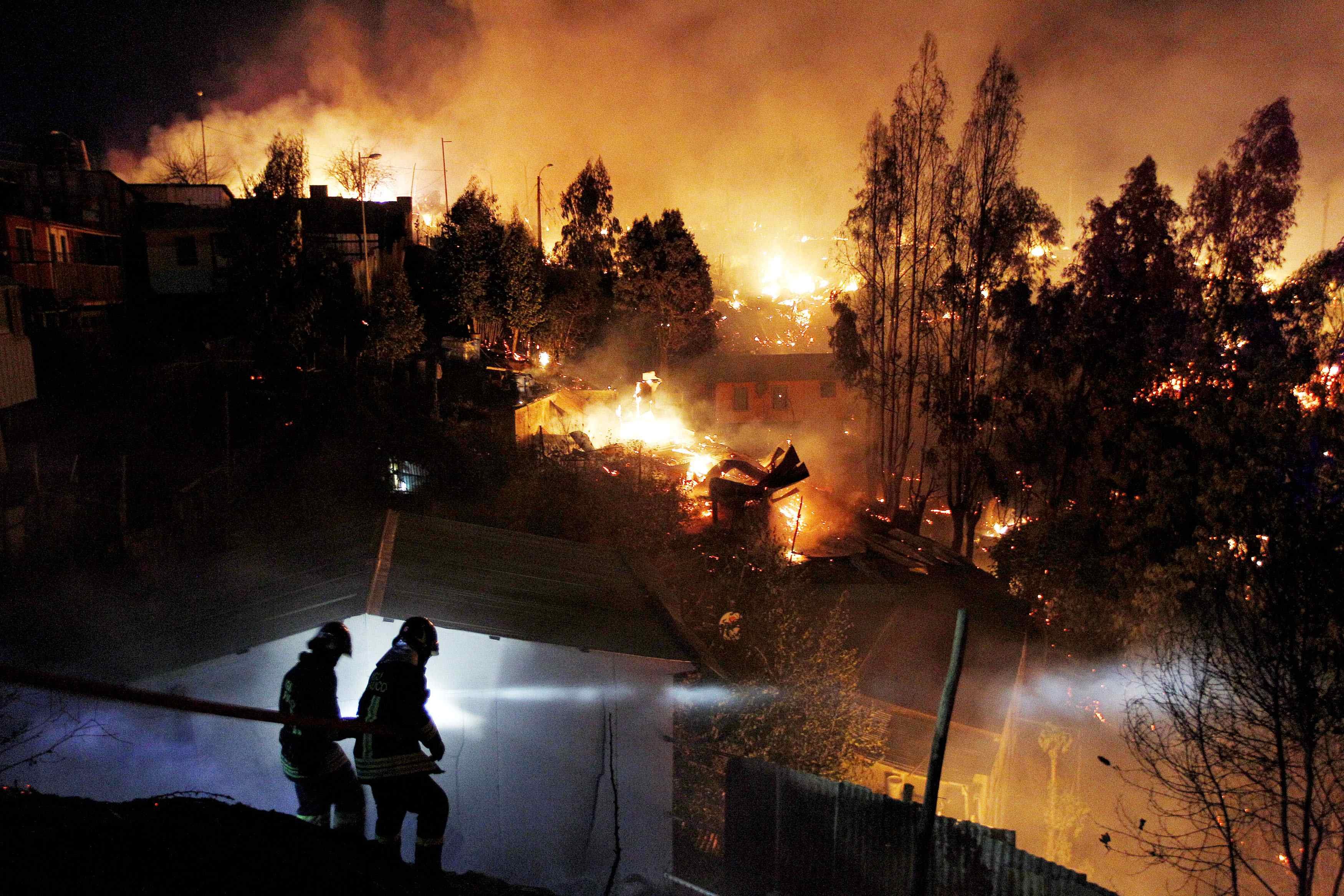 Apr. 13, 2014. Firefighters work to put out a fire in Valparaiso city, northwest of Santiago. At least 12 people were killed and 2,000 houses destroyed over the weekend by a fire that devastated parts of the Chilean port city of Valparaiso, as authorities evacuated thousands and sent in aircraft to battle the blaze.