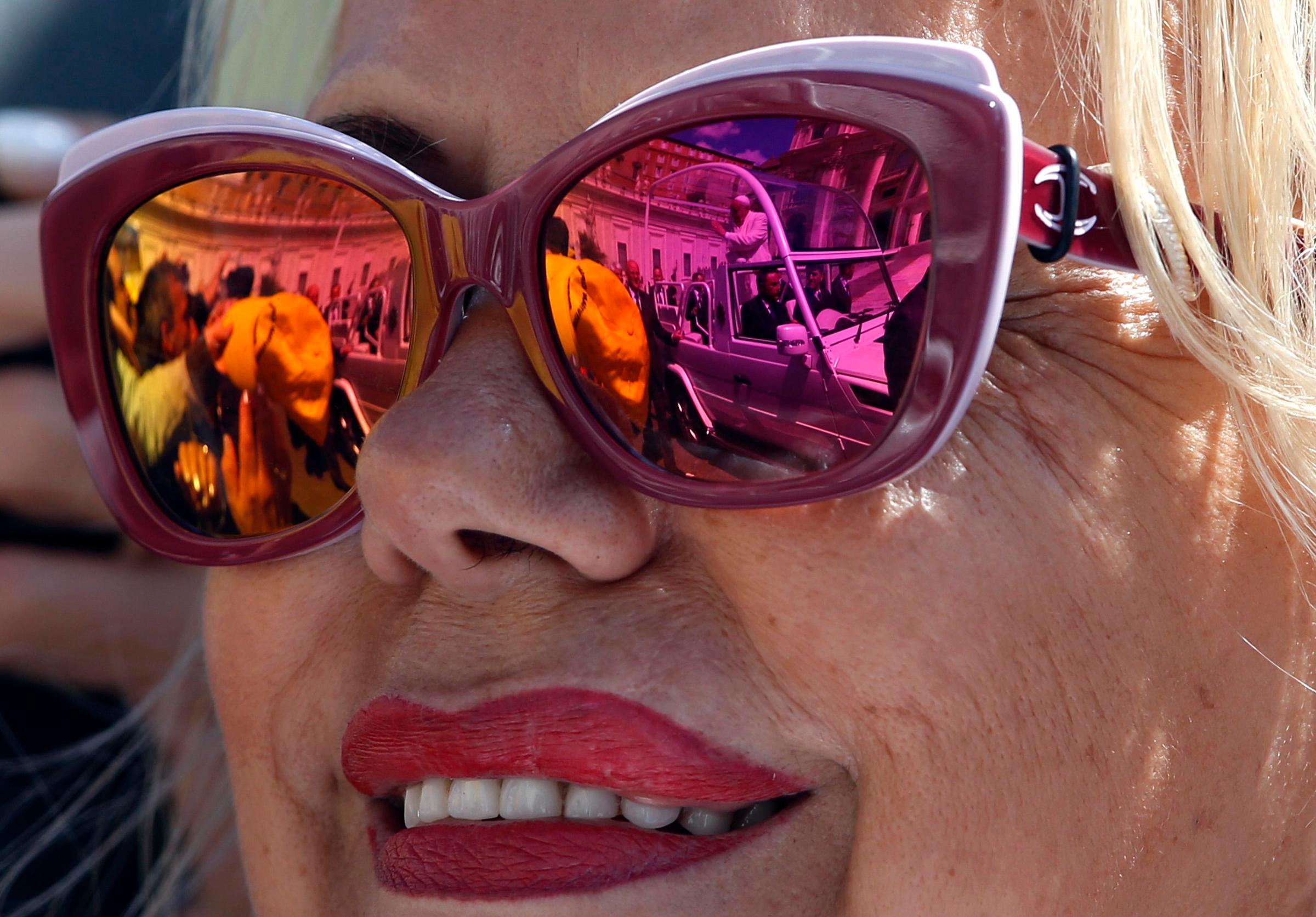 Pope Francis is reflected in the sunglasses of a faithful at the Vatican