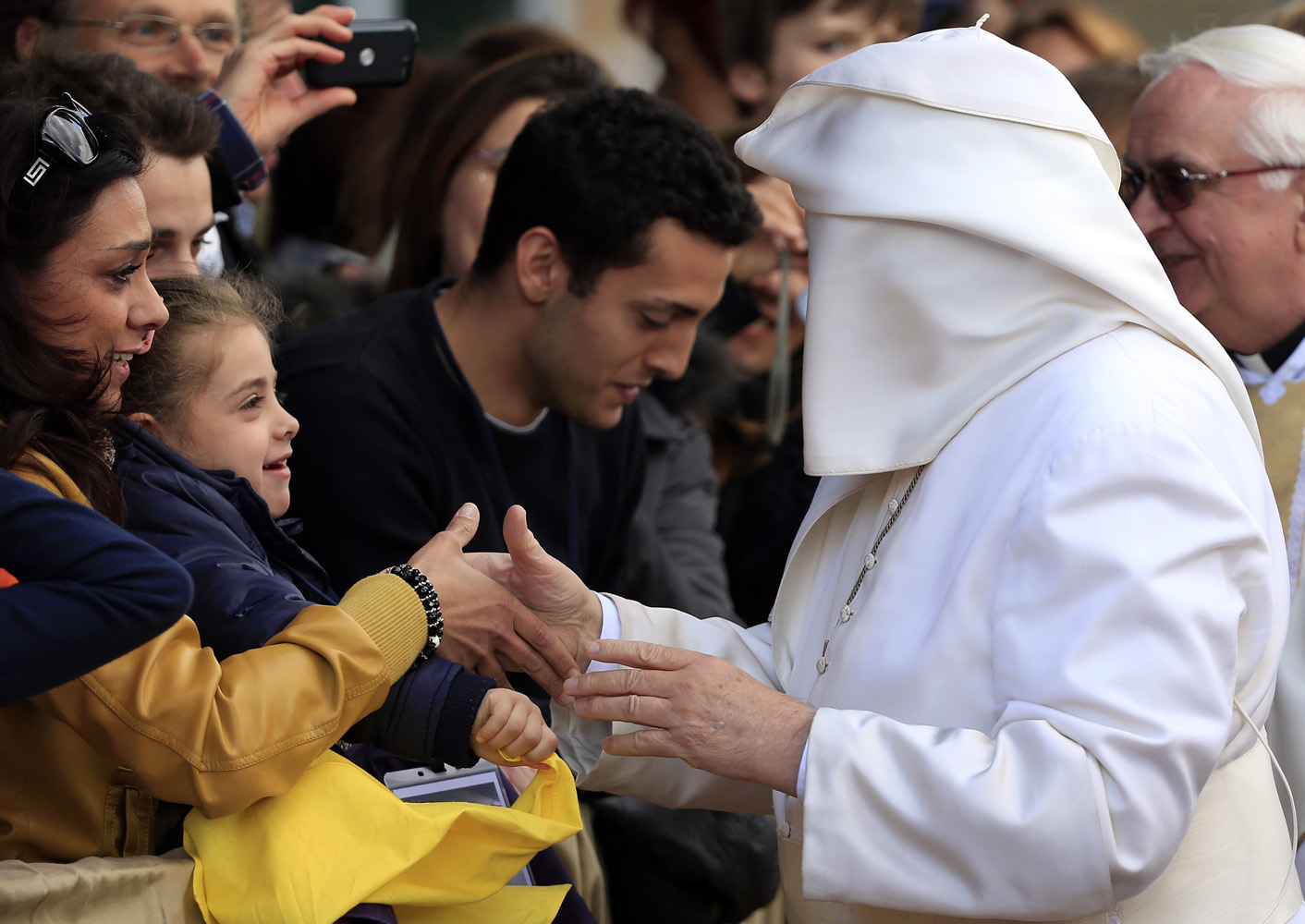 A gust of wind blows Pope Francis's mantle as he greets the faithful at the S. Maria della Provvidenza church in Rome, during the Holy Thursday celebration, April 17, 2014.