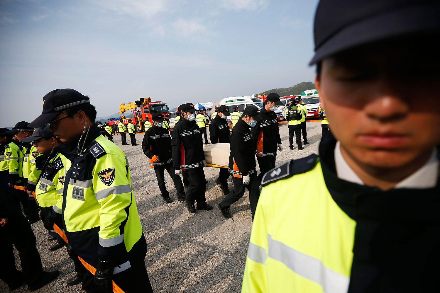 Rescue workers carry the body of passenger who was on the capsized Sewol passenger ship at a port where family members of missing passengers have gathered, in Jindo
