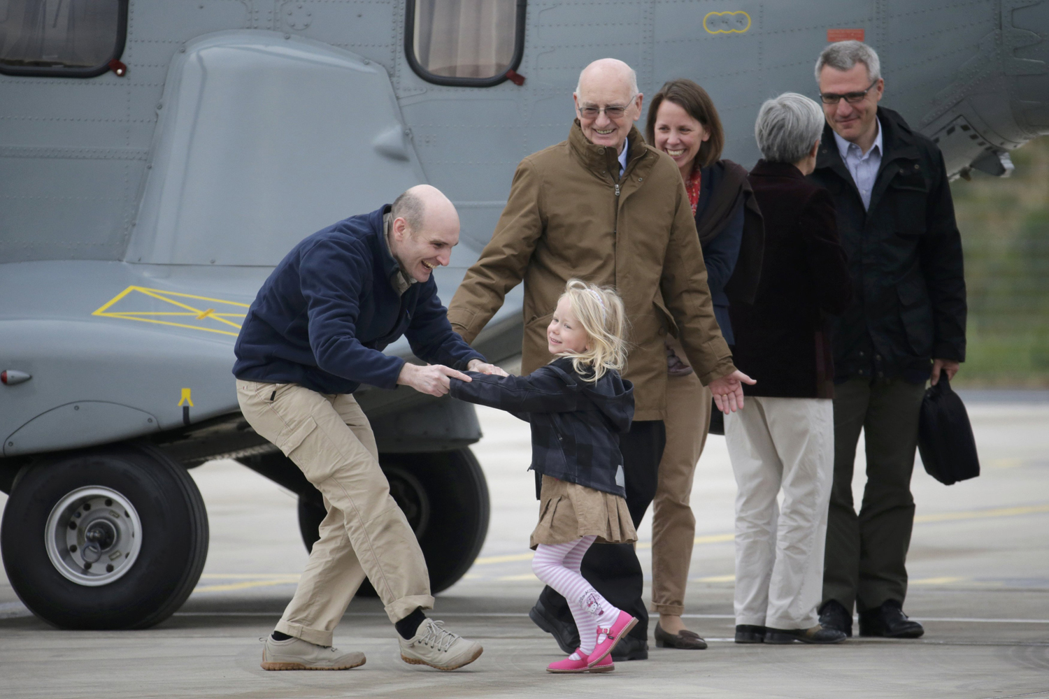 Former French hostage and journalist Nicolas Henin is greeted by his family moments after a transfer by helicopter from Evreux to the military airbase in Villacoublay