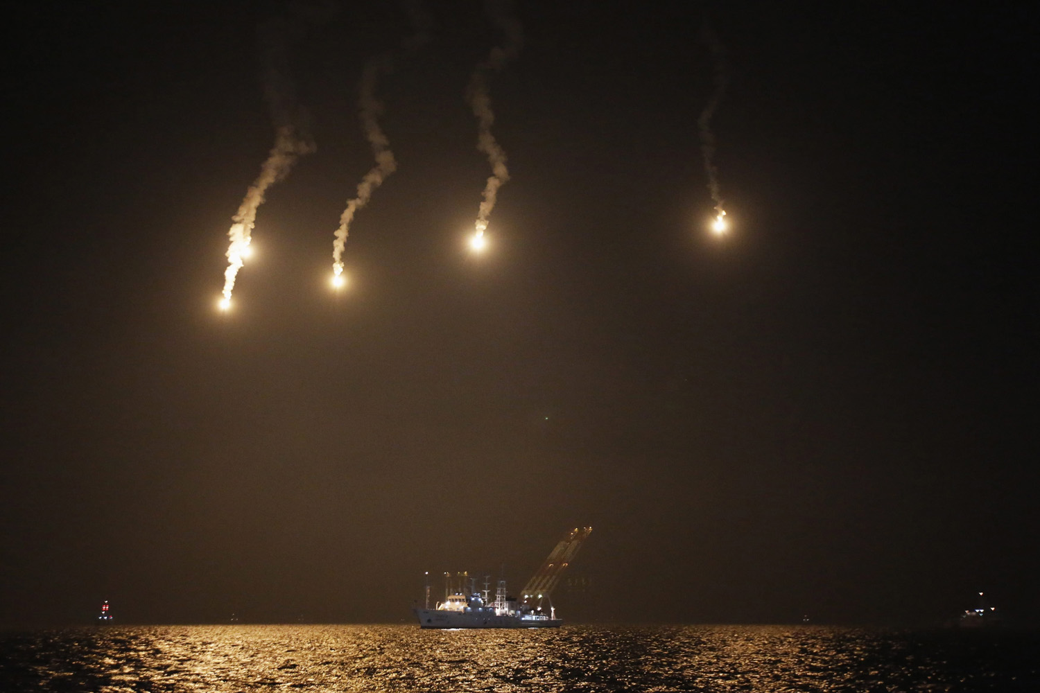 Apr. 22, 2014. Lighting flares are released over the sea off Jindo where the capsized passenger ship Sewol sank. The ferry sank last Wednesday on a routine trip south from the port of Incheon to the traditional honeymoon island of Jeju.