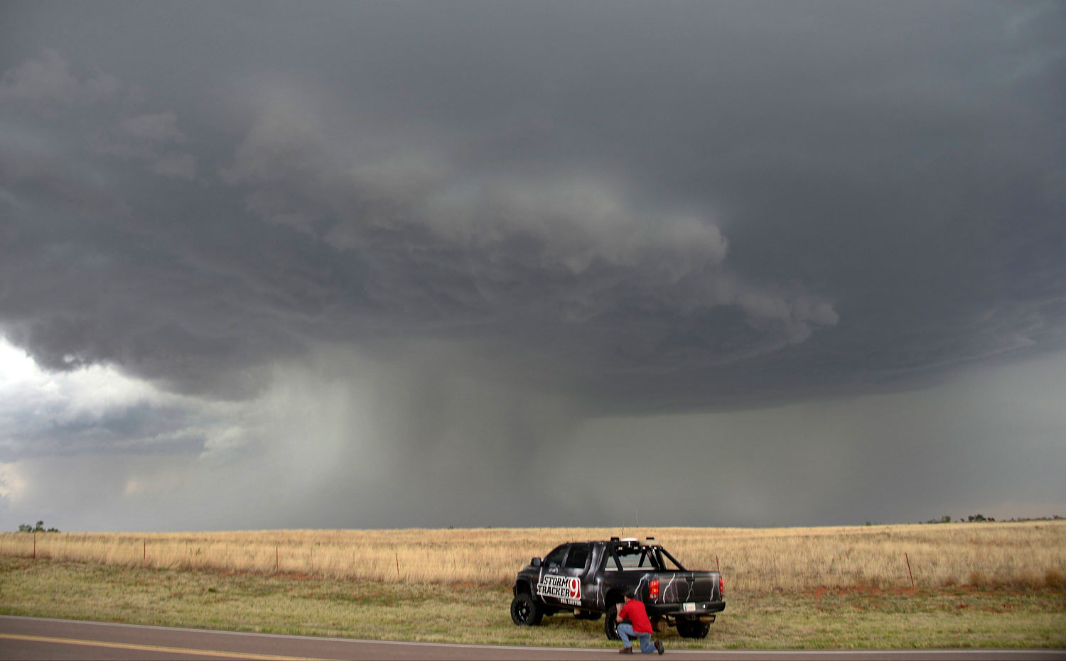 A storm chaser photographer looks at thunderstorms supercells pass through areas in Vinson, Oklahoma