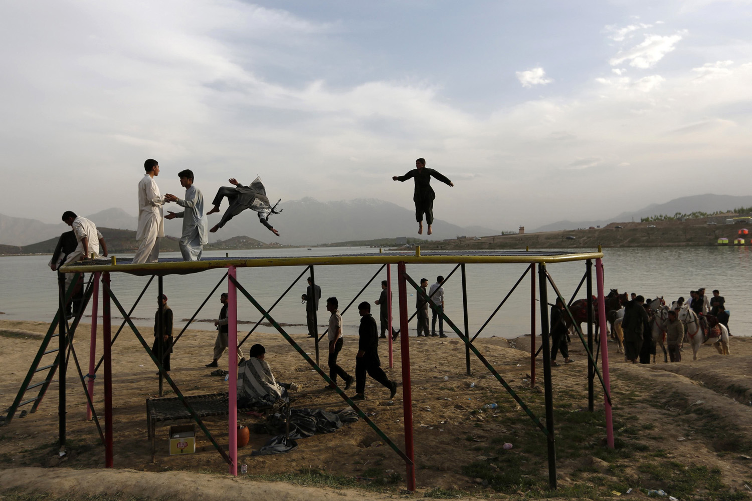 Afghans play on a trampoline along Qargha Lake, on the outskirts of Kabul
