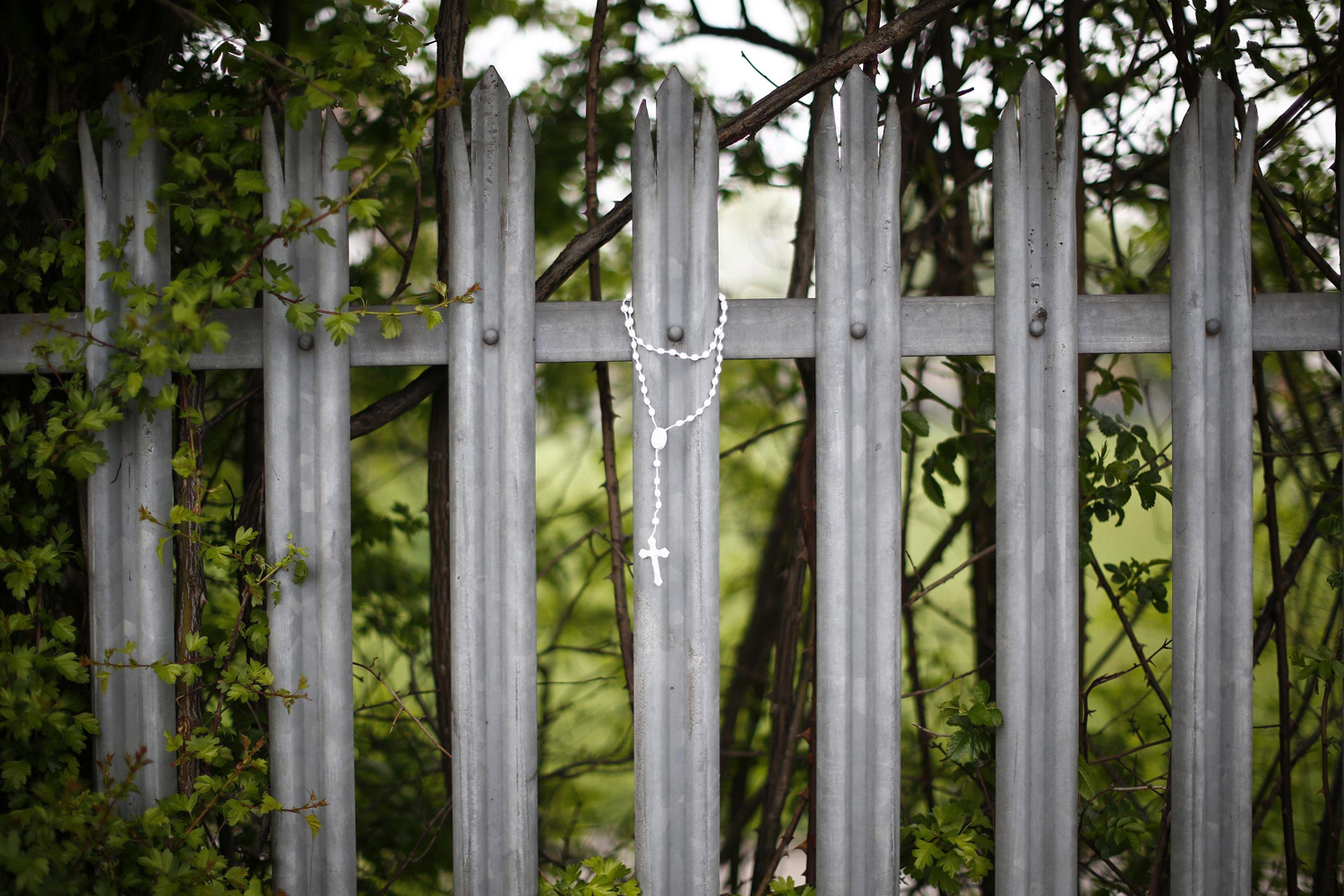 Apr. 29, 2014. A crucifix hangs from the fence of Corpus Christi Catholic College after teacher Anne Maguire was fatally stabbed in Leeds, northern England.