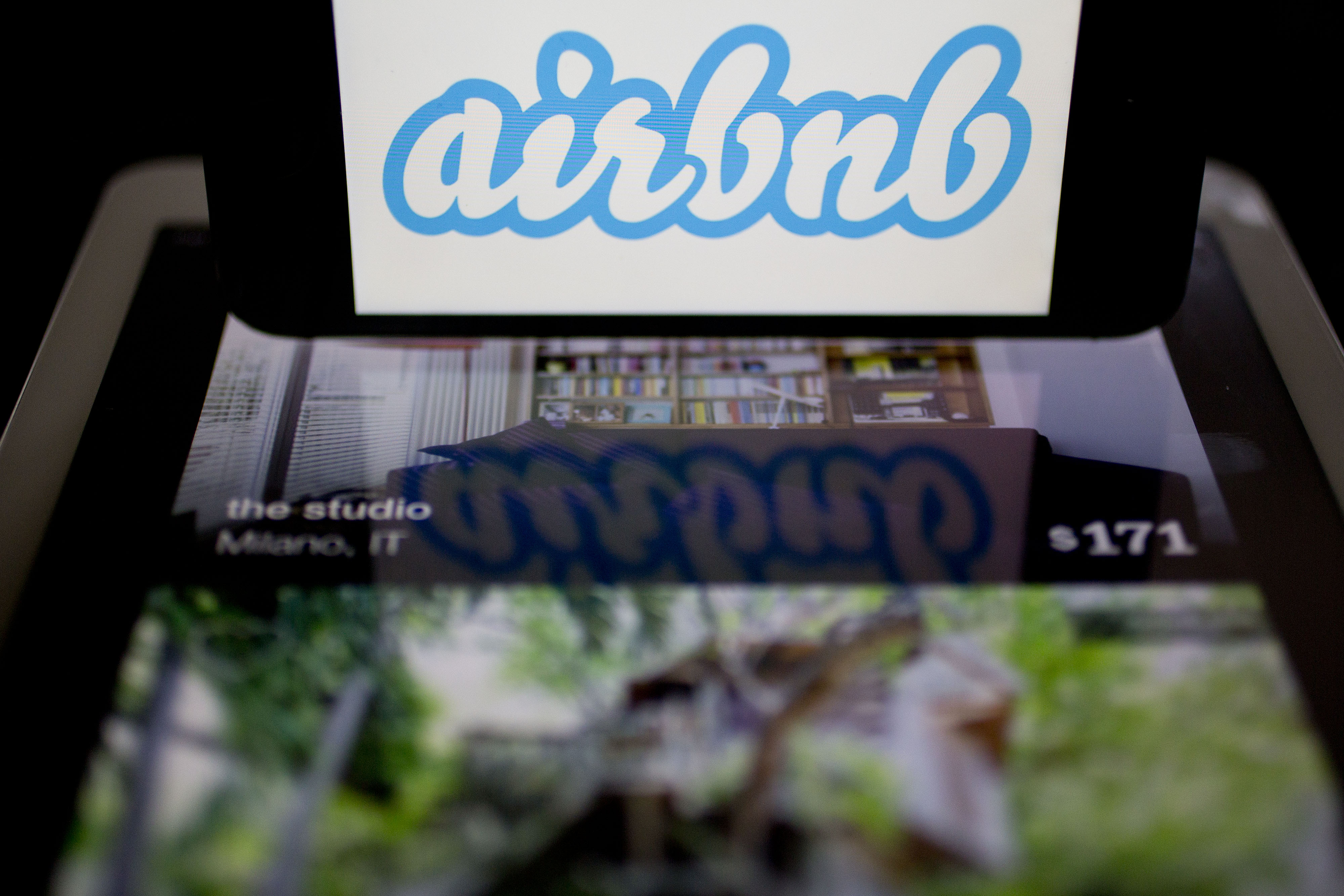 The Airbnb Inc. logo and application are displayed on an Apple Inc. iPhone and iPad in this arranged photograph in Washington, D.C., U.S., on Friday, March 21, 2014. (Bloomberg/Getty Images)