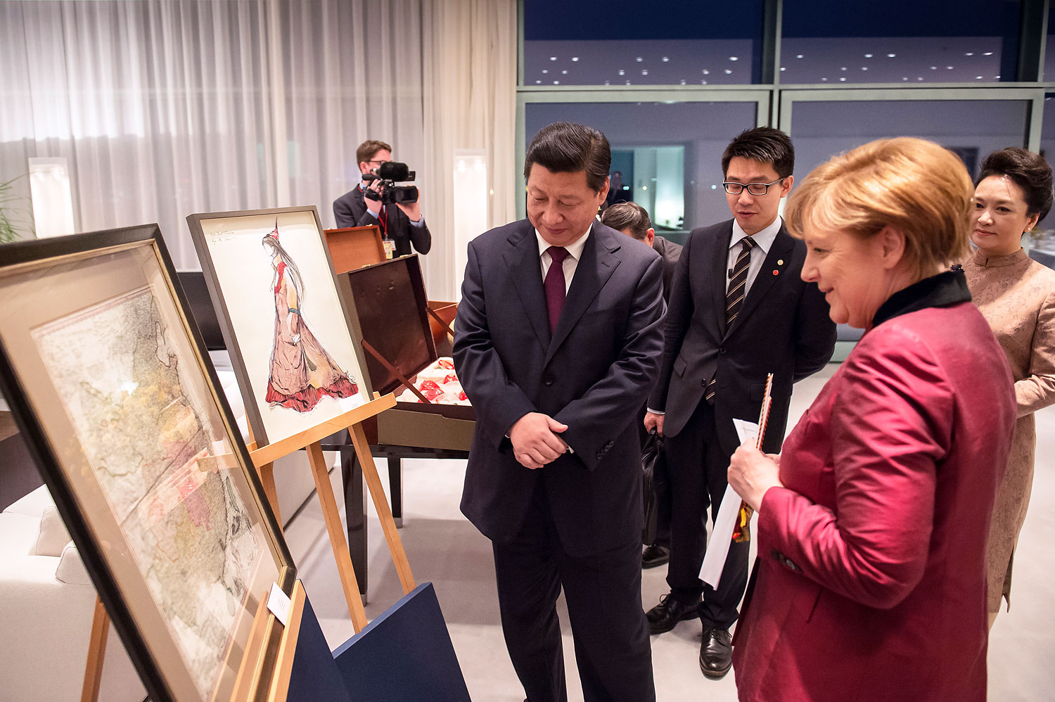 German Chancellor Angela Merkel presents Chinese President Xi Jinping with a a map of China from the 18th century at the Chancellor's Office on March 28, 2014, in Berlin (BPA/Getty Images)