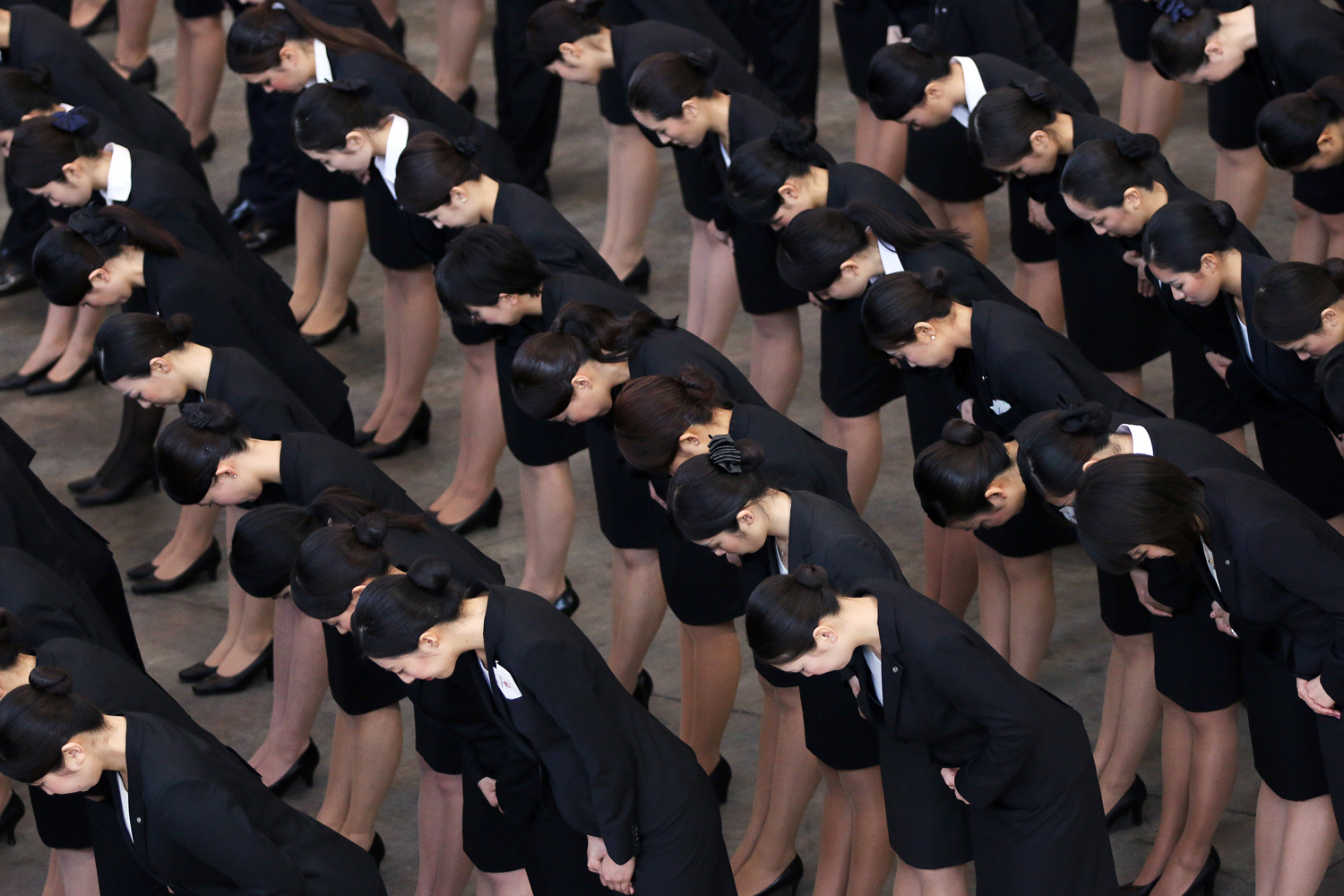 Apr. 1, 2014. Japan Airlines Co. (JAL) group companies' new employees bow during a welcoming ceremony at the company's hangar near Haneda Airport in Tokyo, Japan.