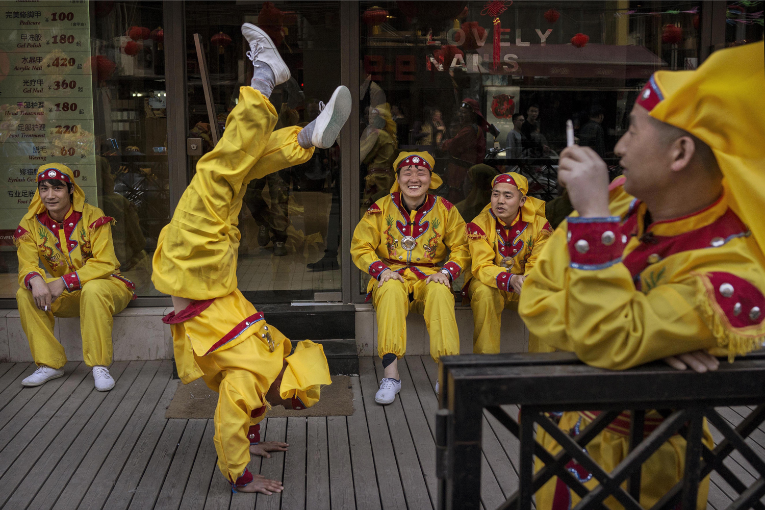 A Chinese dragon dancer does a handstand as he and other performers take a break while shooting a film in the Sanlitun area on April 3, 2014 in Beijing. The popular traditional dance is often performed during the annual Spring Festival at Chinese New Year.