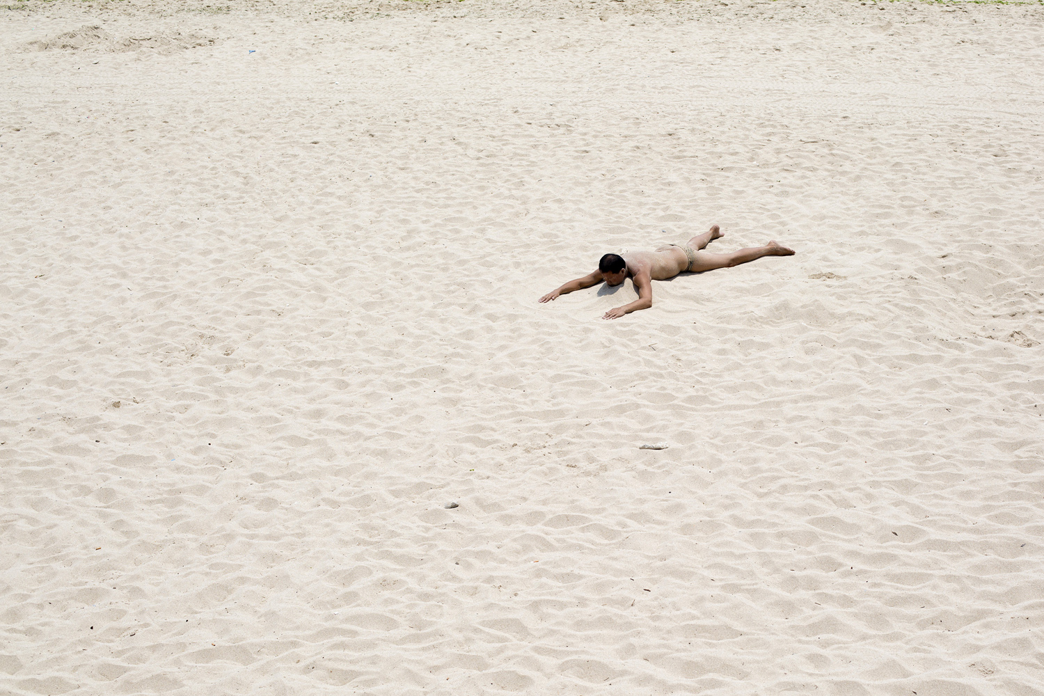 Apr. 7, 2014. A man sunbathes on the beach in the Dadonghai district of Sanya, Hainan Province, China.