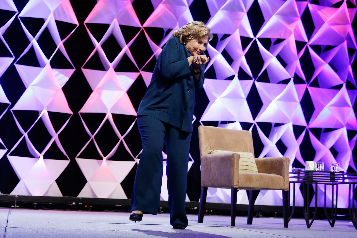Former Secretary of State Hillary Clinton ducks after a woman threw an object toward her while she was delivering remarks at the Institute of Scrap Recycling Industries conference on April 10, 2014 in Las Vegas, Nevada.