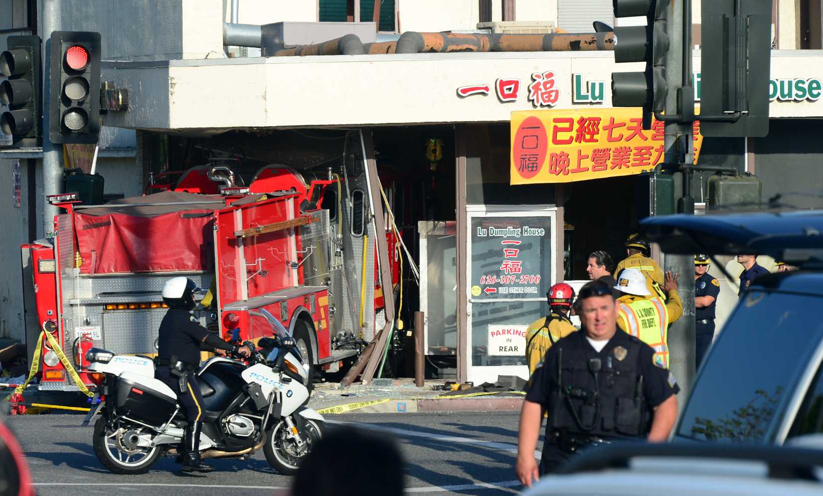 A motorcycle policeman arrives on the scene in Monterey Park, California on April 16, 2014, where two fire engines - one from the Monterey Park Fire department, another from the Alhambra Fire Department - chasing a fire crashed into each other with one barreling into a business, the Lu Dumpling House, leaving fifteen people injured. (Frederic J. Brown—AFP / Getty Images)