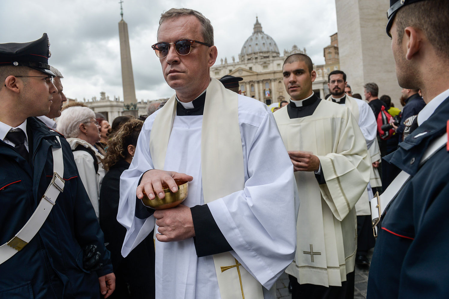 Priests arrive in Saint Peter's Square to give communion to pilgrims.