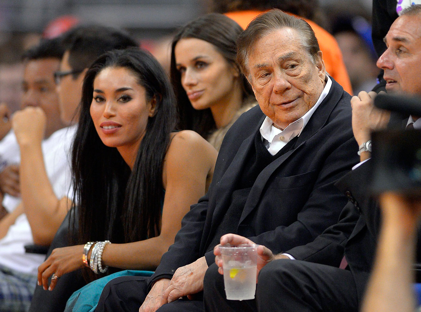 Los Angeles Clippers owner Donald Sterling and V. Stiviano watch the Clippers play the Sacramento Kings during an NBA game in Los Angeles on Oct. 25, 2013 (Mark J. Terrill—AP)
