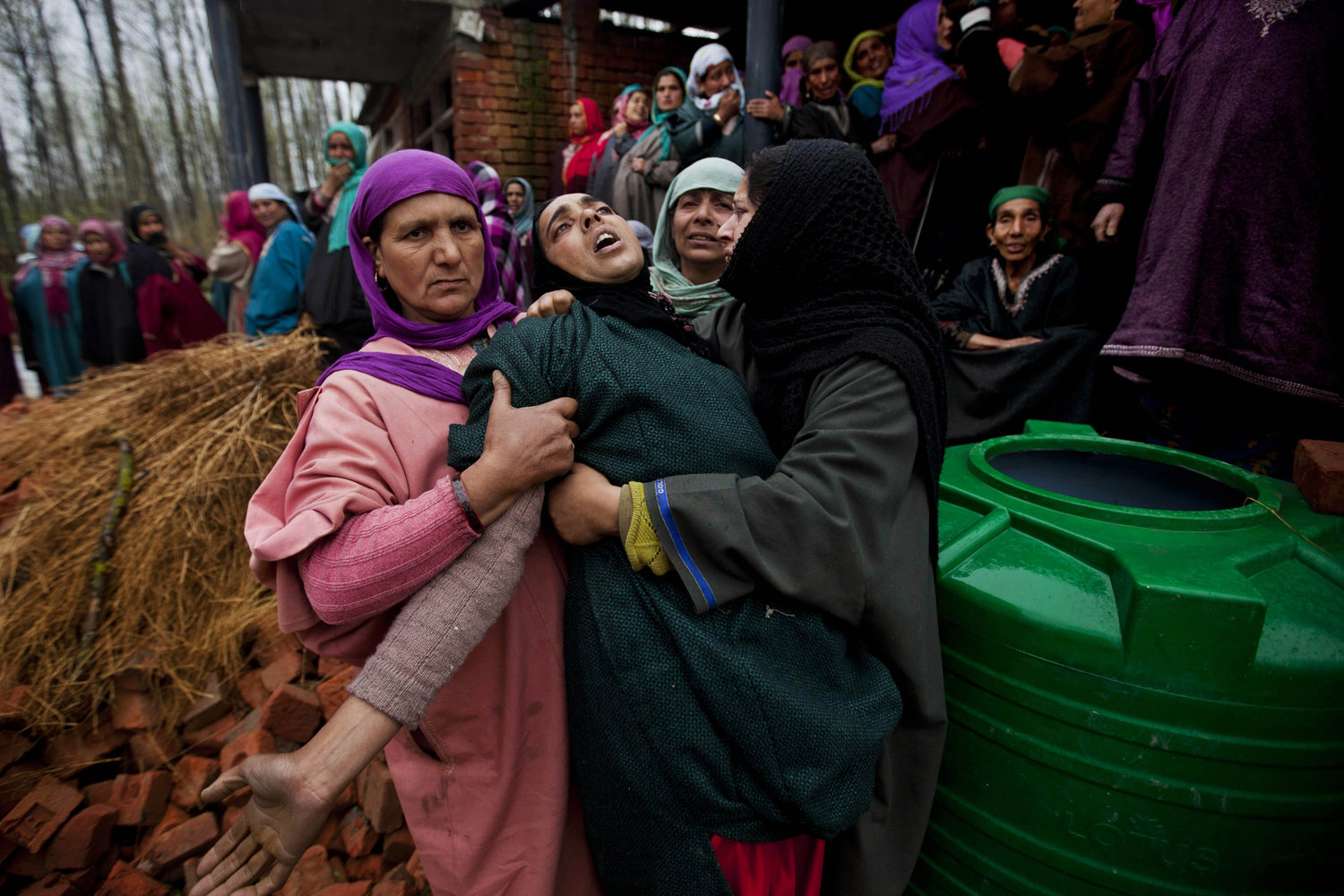 Apr. 18, 2014. Unidentified women try to comfort the wailing relative of Mohammad Amin Pandit, a pro-India party worker and a rural body head, during his funeral procession in Gulzarpora village. Police in Indian Kashmir say unidentified gunmen shot dead the political worker late Thursday night.