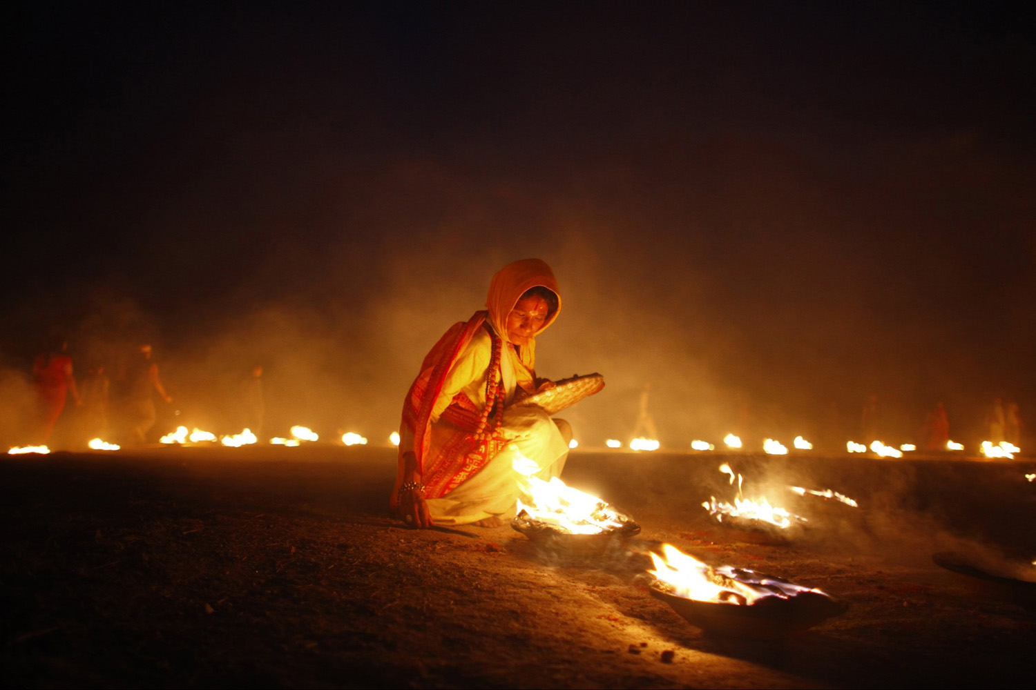 Apr. 22, 2014. A Nepalese Hindu devotee lights an oil lamp during the last day of a Mahayagya, holy rituals that last for seven days, near Pashupatinath temple in Katmandu, Nepal.