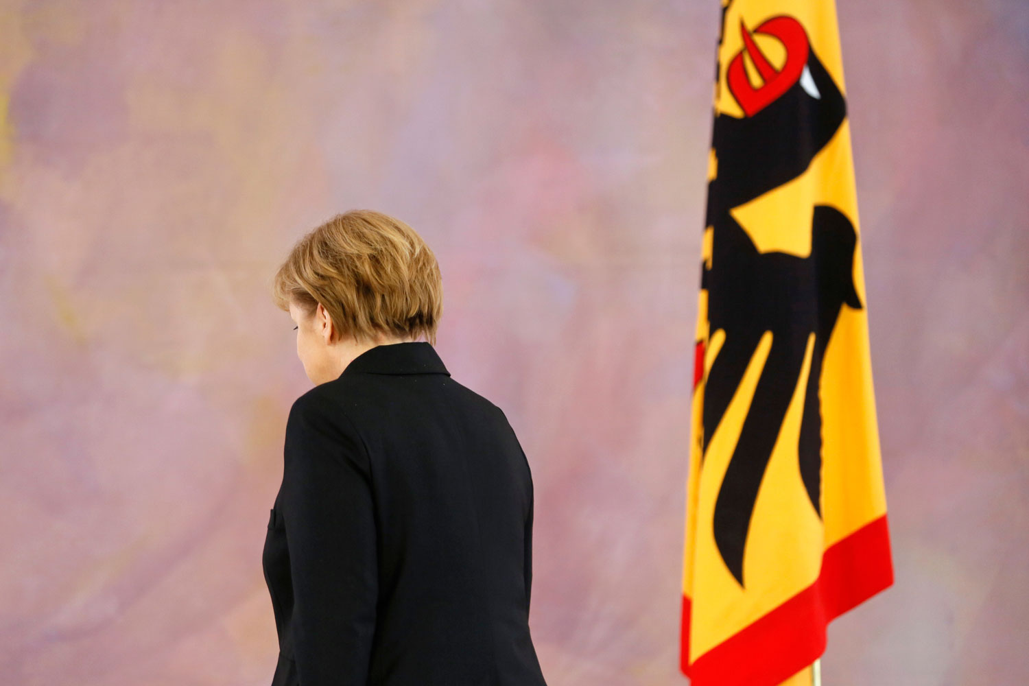 German President Joachim Gauck gives Chancellor Angela Merkel her new appointment papers during a ceremony in which Gauck appointed the new German government cabinet on December 17, 2013.