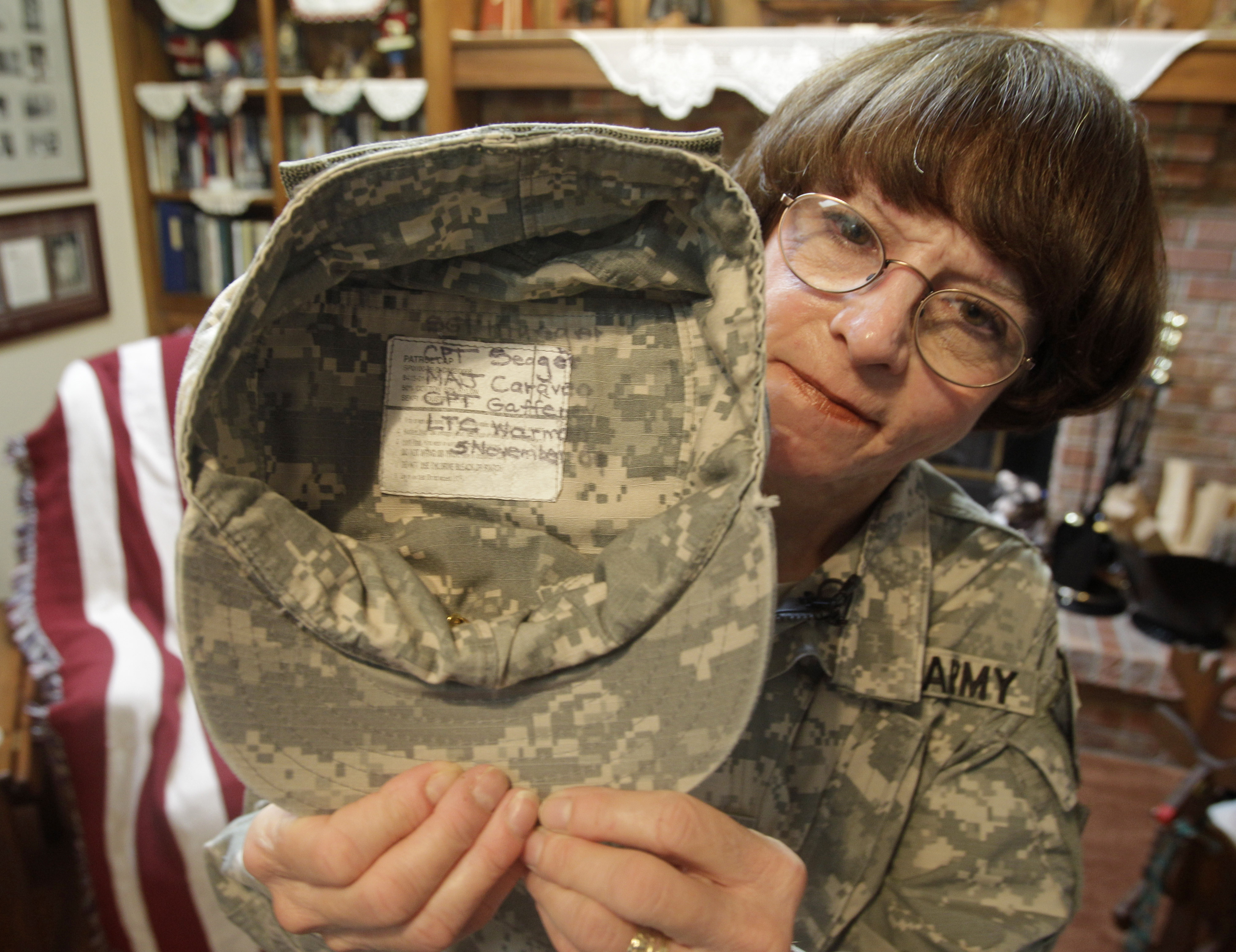 Kathy Platoni holds up her cap with the names of colleagues killed at Fort Hood in 2009 written inside. (Al Behrman—AP)