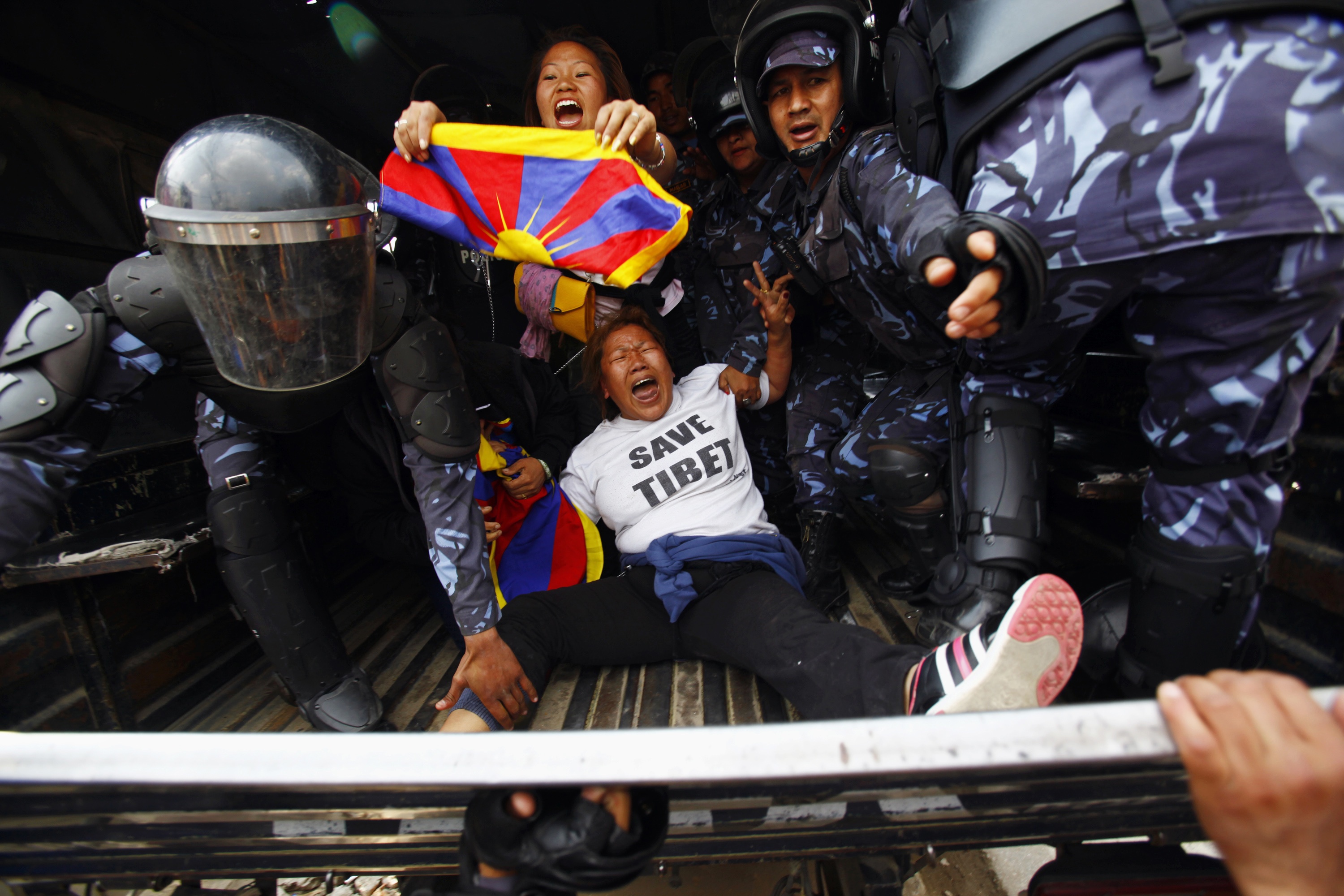 Nepali policemen detain exiled Tibetans participating in a protest outside the Chinese embassy in Kathmandu on March 10, 2014 (Niranjan Shrestha—Associated Press)