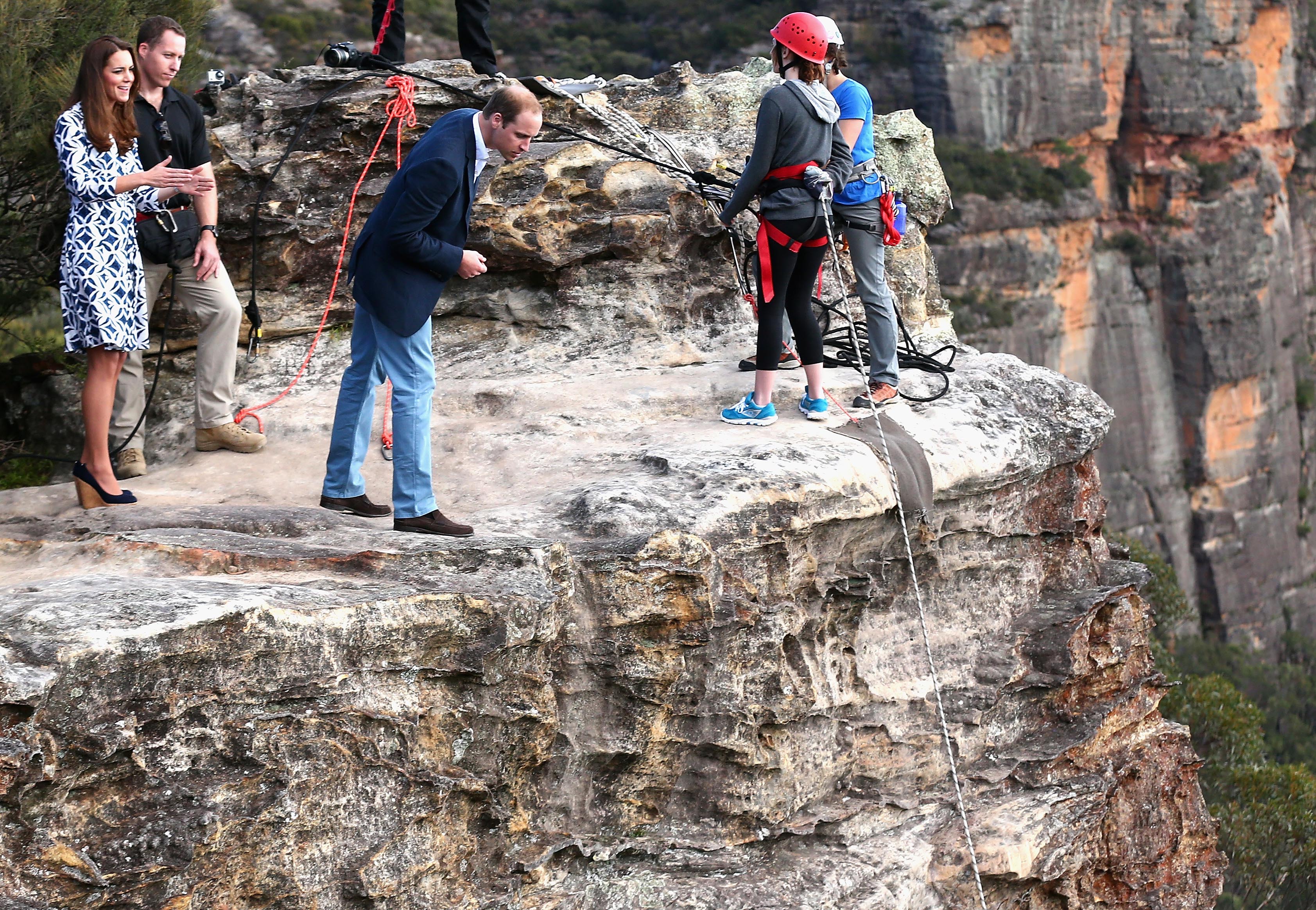 Britain's Prince William, third left, looks over the cliff edge as he and his wife Kate, the Duchess of Cambridge, left, observe abseiling and team building exercises at Narrow Neck Lookout near Katoomba, Australia, Thursday, April 17, 2014. (Ryan Pierse / AP)
