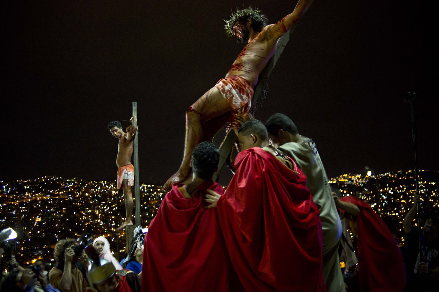 Apr. 18, 2014. Residents reenact Jesus Christ's crucifixion on a hilltop in the Petare shanty town during Holy Week in Caracas, Venezuela.