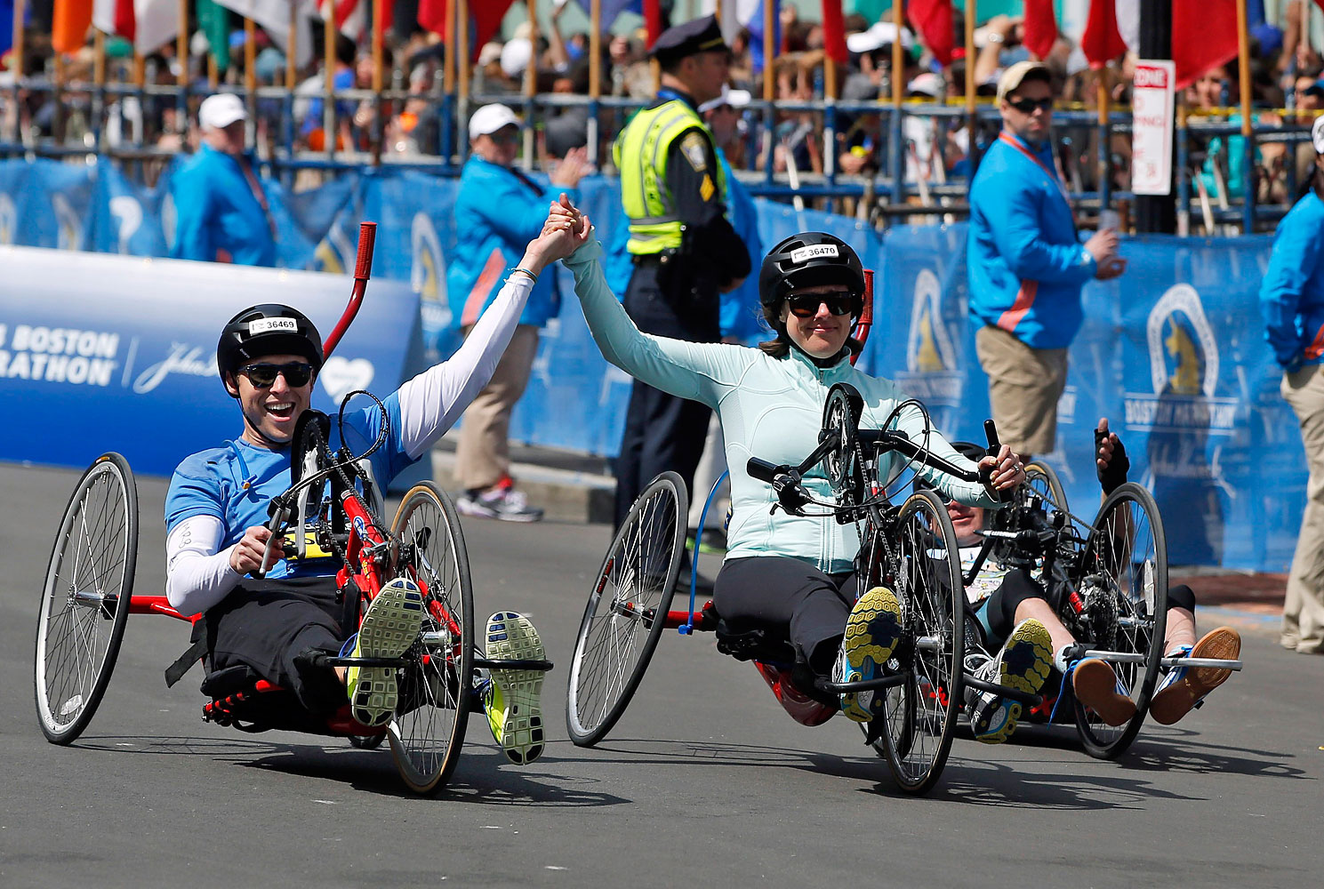 Boston Marathon husband and wife bombing survivors Patrick Downes and Jessica Kensky, who each lost a leg in last year's bombings, roll across the finish line in the 118th Boston Marathon, April 21, 2014 in Boston. (Elise Amendola—AP)