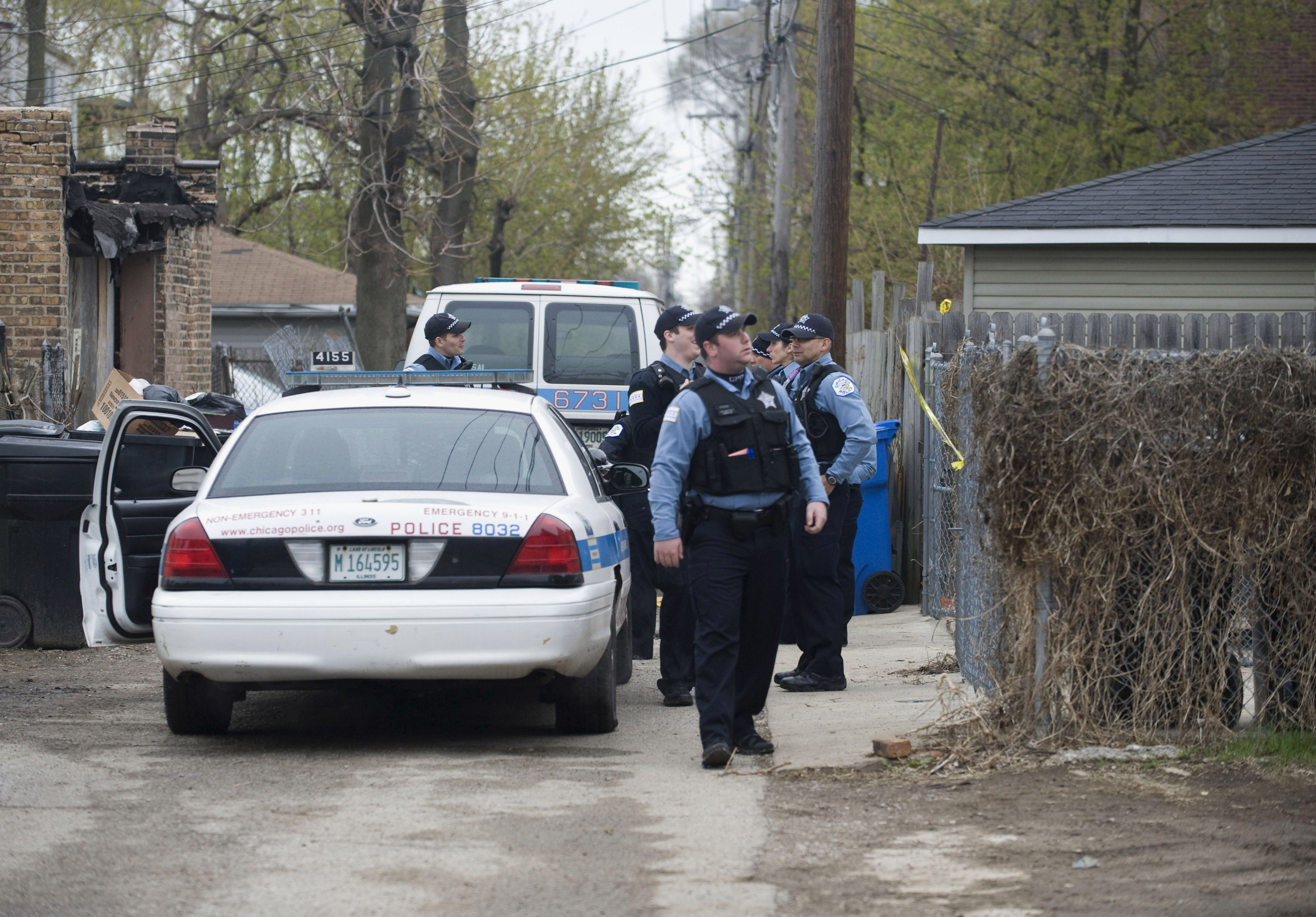 Police stand outside a residence in Chicago after a 14-year-old girl was fatally shot and another girl wounded in the Back of the Yards neighborhood in Chicago, April 28, 2014. (Richard A. Chapman—Sun-Times Media/AP)