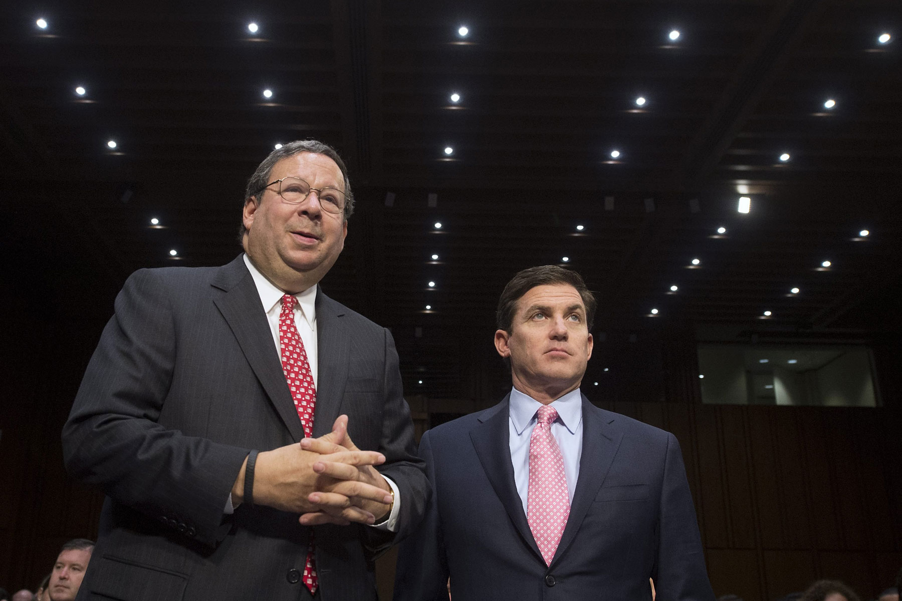 From left: David Cohen, executive vice president of the Comcast Corporation, speaks with Arthur Minson Jr., executive vice president and CFO of the Time Warner Cable Inc., before the start of a Senate Judiciary Committee hearing on Capitol Hill in Washington, April 9, 2014. (Michael Reynolds—EPA)
