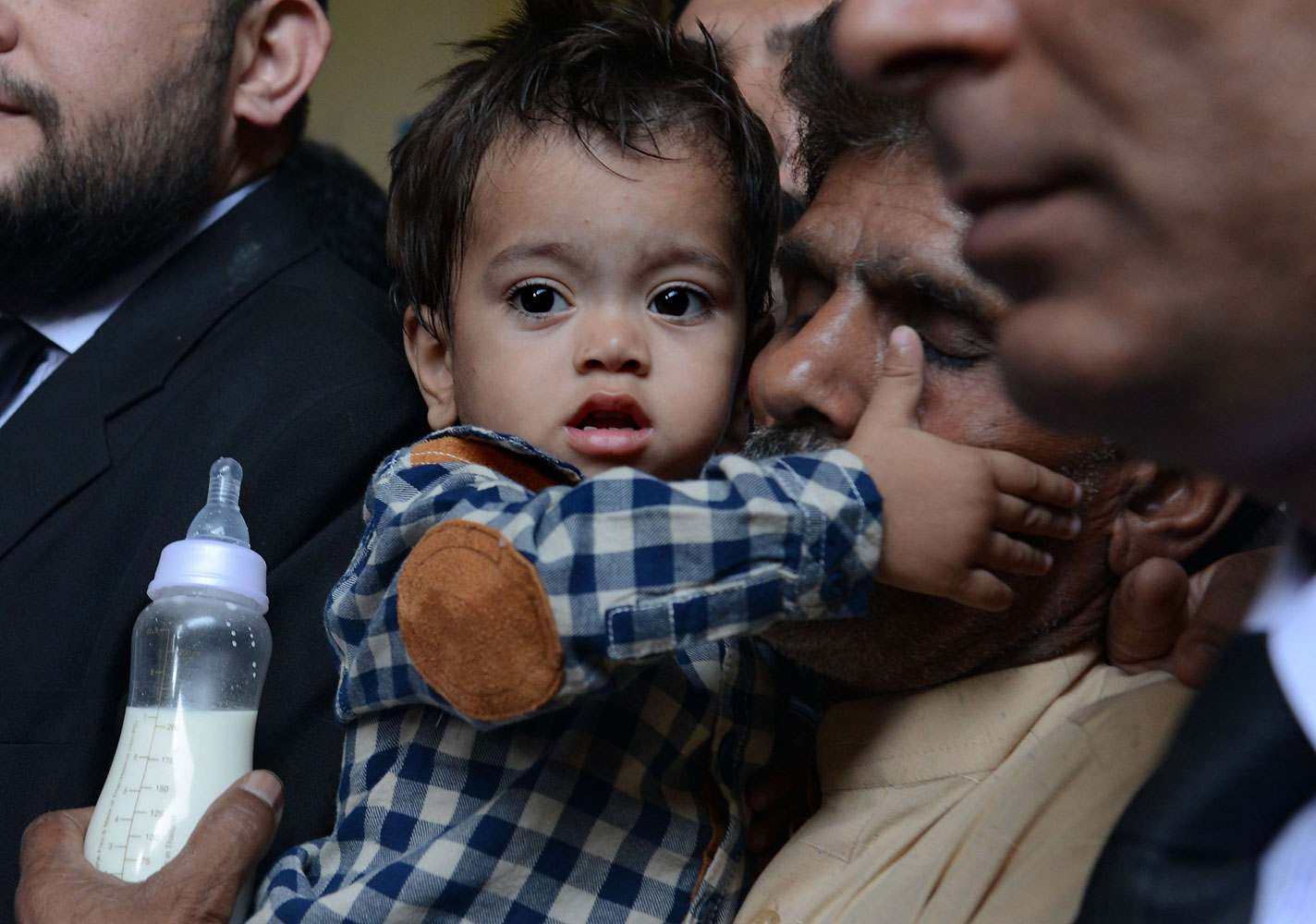 Nine month Pakistan toddler Mohammad Musa is held by his grandfather Muhammad Yasin for a court hearing in Lahore on April 12, 2014. (Arif Ali—AFP/Getty Images)