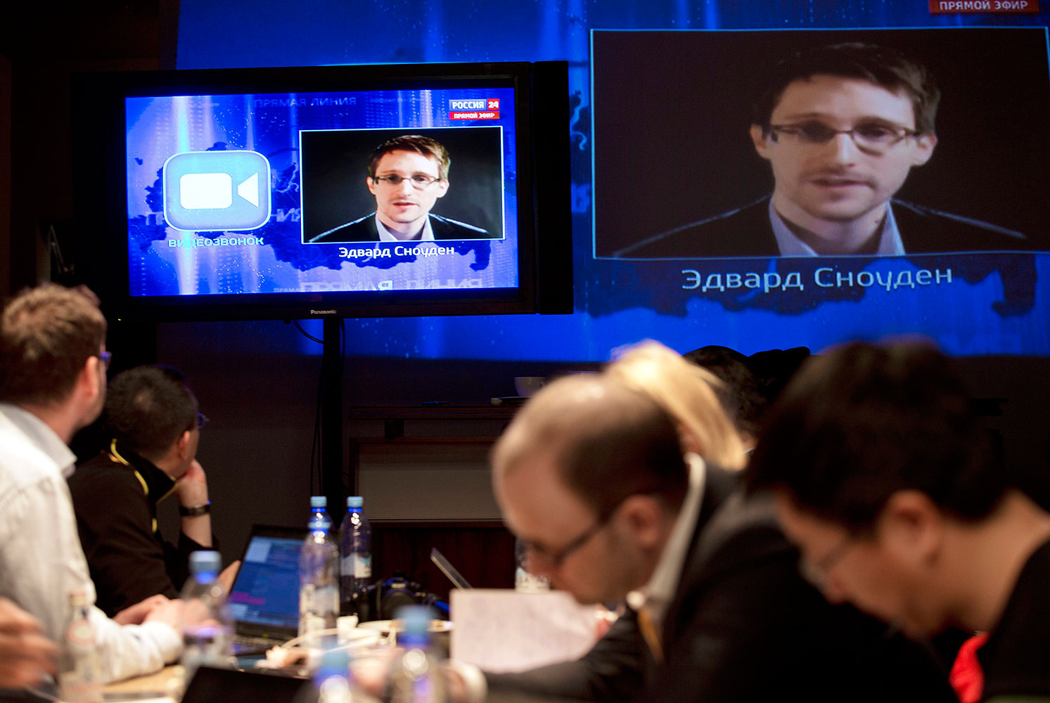 Edward Snowden, displayed on television screens, asks a question to Russian President Vladimir Putin during a nationally televised question-and-answer session, in Moscow, Thursday, April 17, 2014.