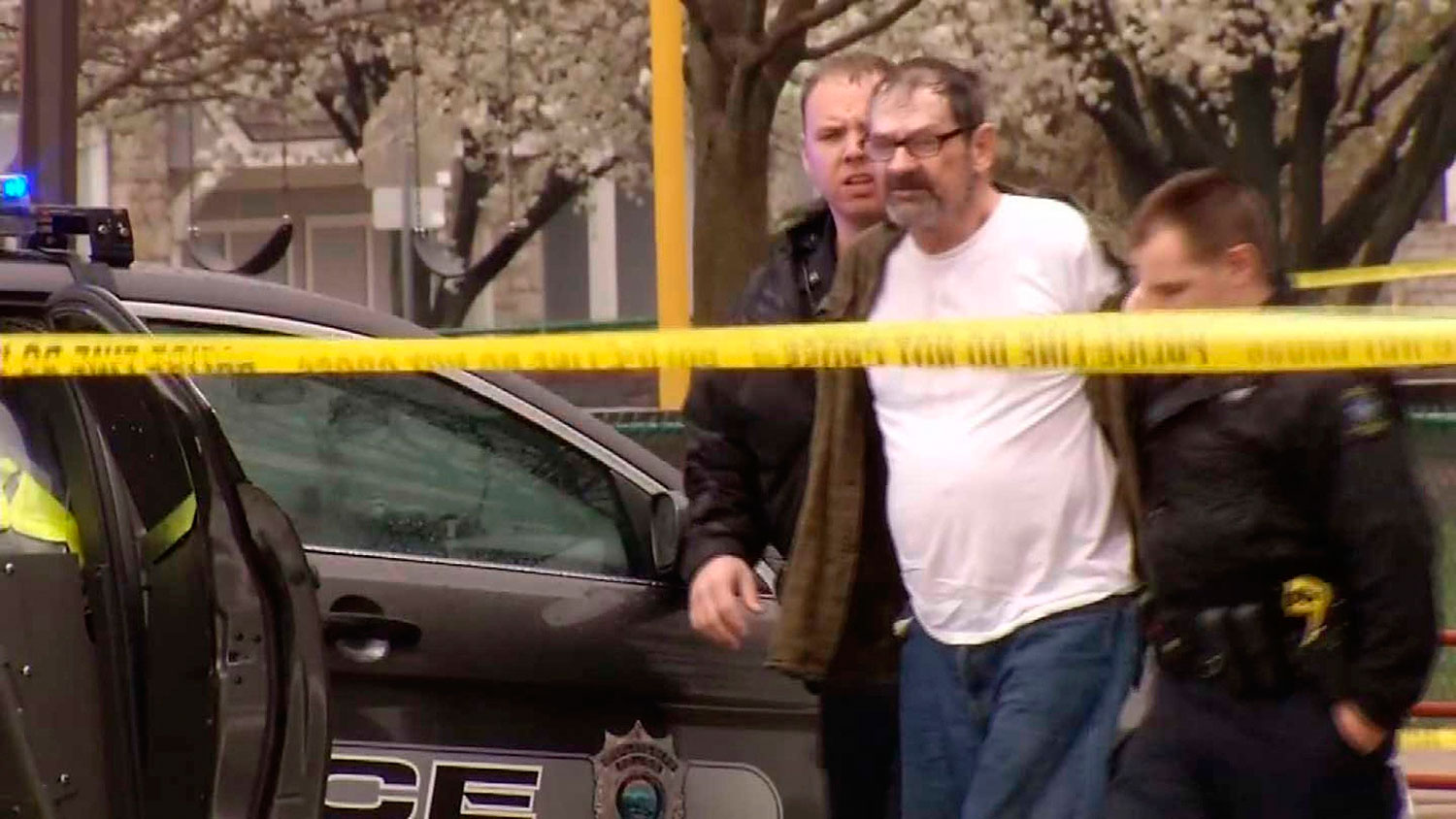 Frazier Glenn Cross, 73, of Aurora, Missouri, is led to a police car after his arrest following shooting incidents which killed three people at two Jewish centers on Sunday in Overland Park, south of Kansas City, Kansas in a still image from video April 13, 2014.
