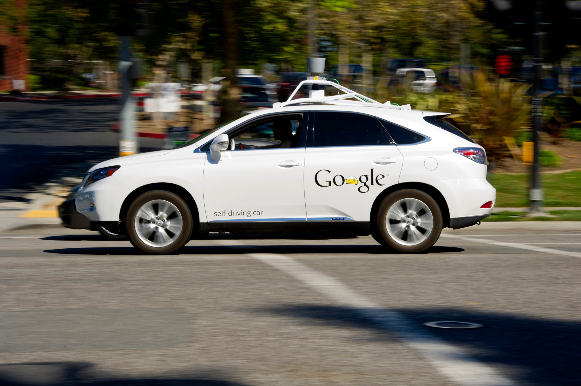 A driver drives a Google Inc. self-driving car in front of the company's headquarters in Mountain View, California on September 27, 2013.