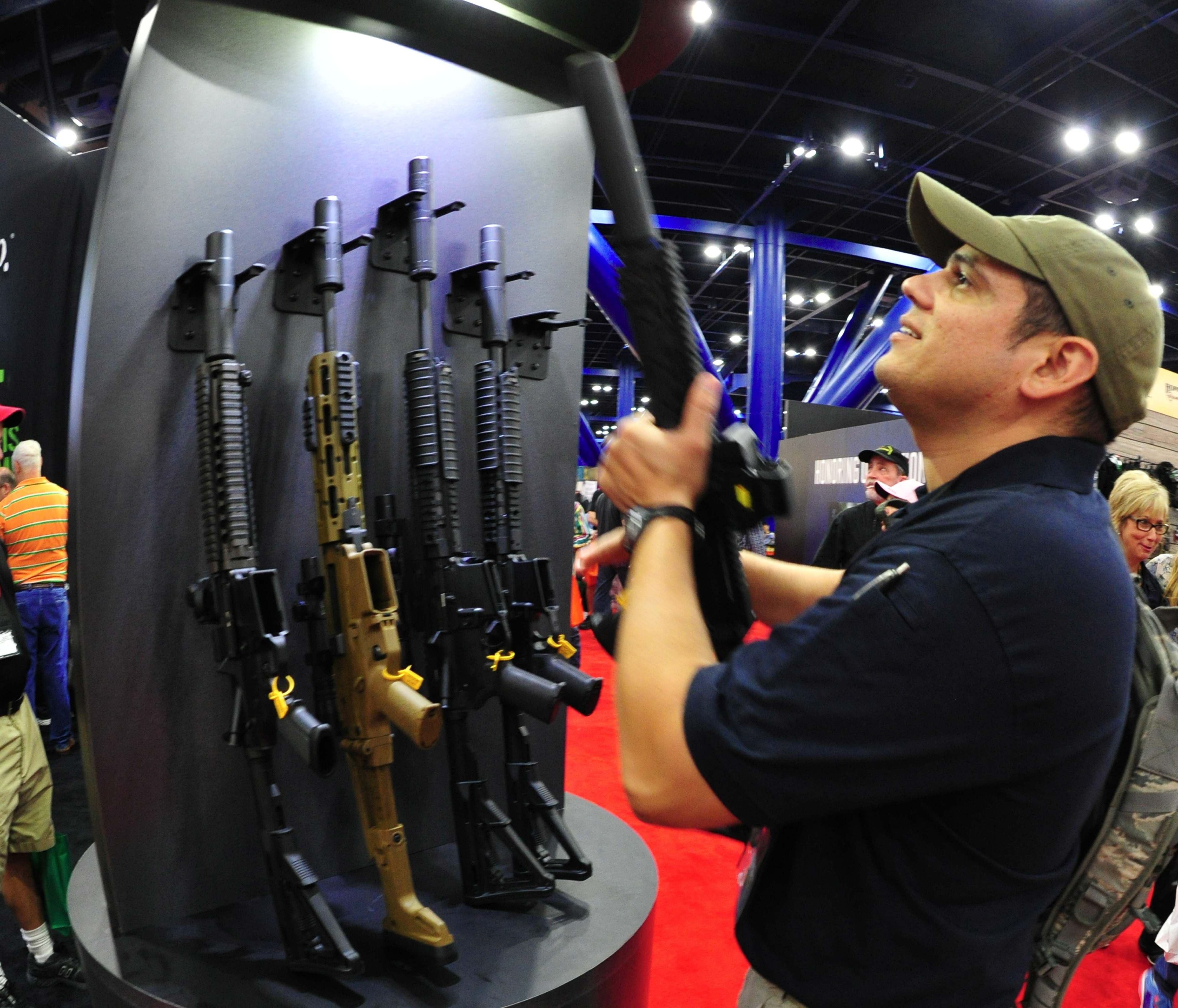 A convention goer picks up a weapon equipped with a silencer during the 142nd annual National Rifle Association(NRA) Convention at the George R. Brown Convention Center May 4, 2013 in Houston, Texas. (KAREN BLEIER&mdash;AFP/Getty Images)