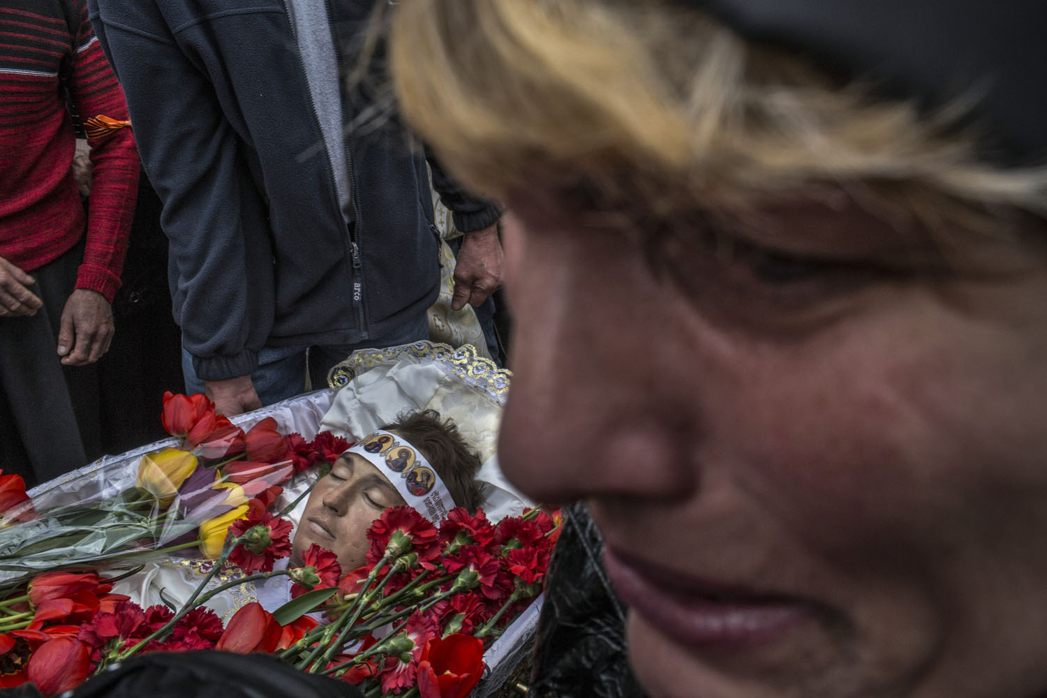 Apr. 22, 2014. A woman mourns as one of the bodies of three men killed in a shootout days earlier passes, during the mens' funeral outside the Orthodox Church of the Holy Spirit in Slovyansk, Ukraine.