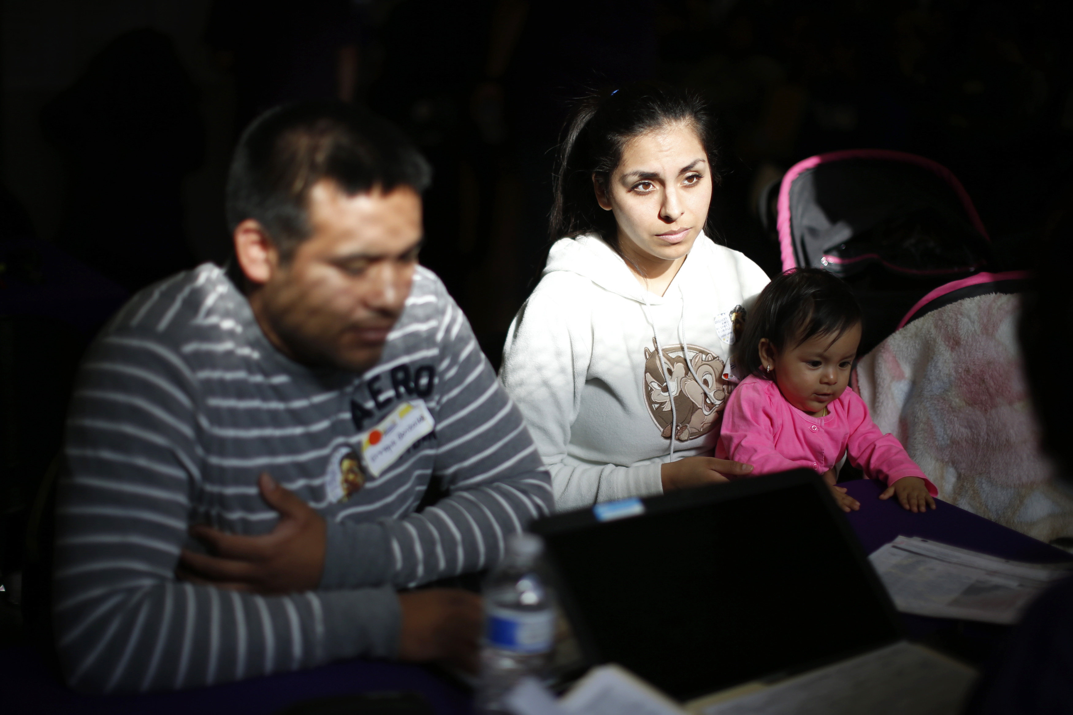From left: Enrique Gonzalez, 22, Janet Regalado, 21, and their nine-month-old daughter Kayleen Gonzalez sign up for health insurance at an enrolment event in Commerce, Calif., on March 31, 2014. (Lucy Nicholson—Reuters)