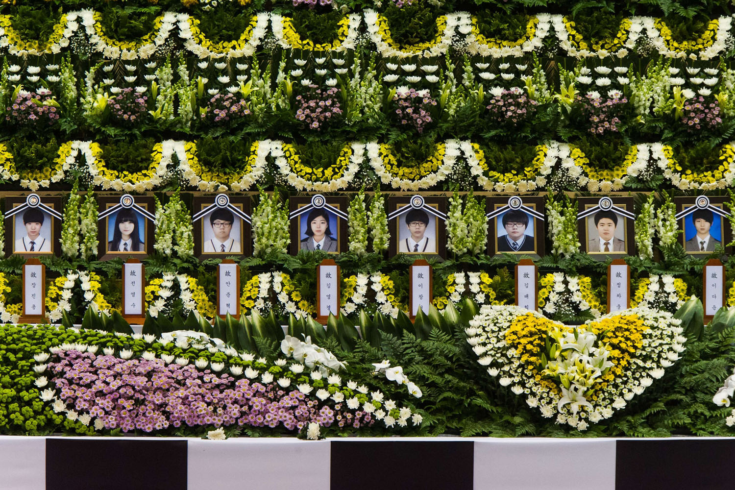 Apr. 23, 2014. Portraits are displayed upon a newly opened group memorial altar for the victims from the sunken South Korean ferry  Sewol  at the Ansan Olympic memorial hall.