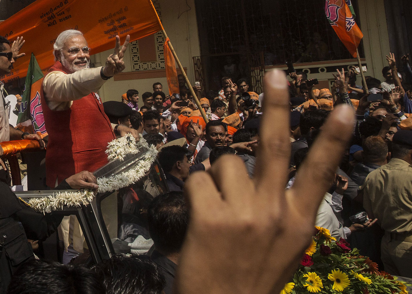 Bharatiya Janata Party leader Narendra Modi gestures to supporters as he rides in an open jeep on his way to file nomination papers on April 9, 2014 in Vadodra, India.
