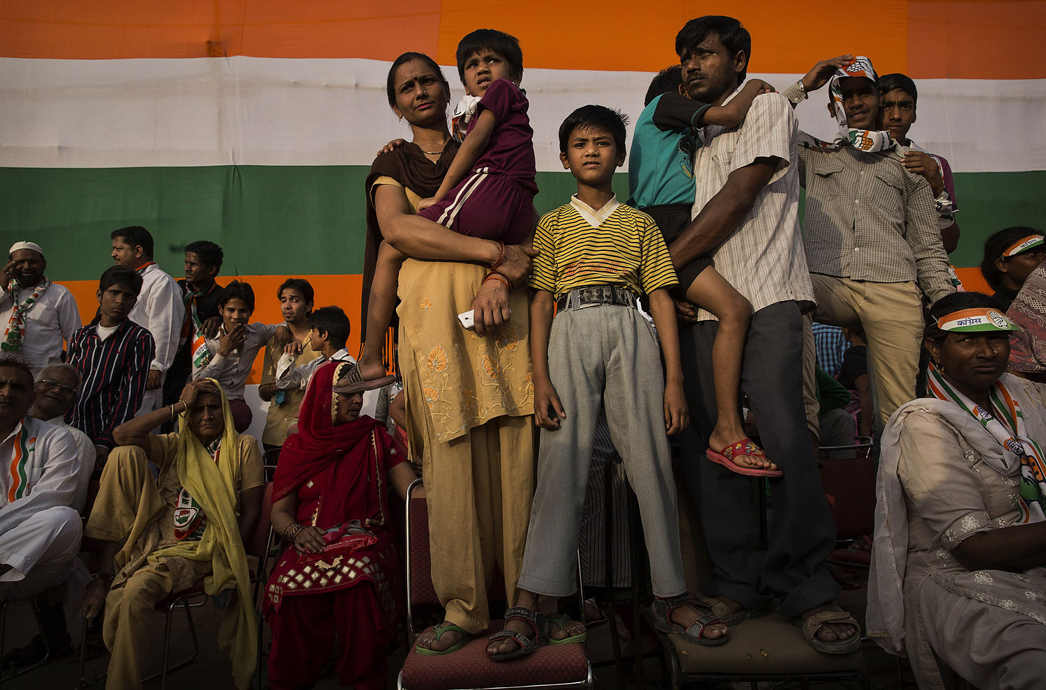 An Indian family listens as Rahul Gandhi, leader of India's ruling Congress Party speaks at a rally on April 6, 2014 in New Delhi.