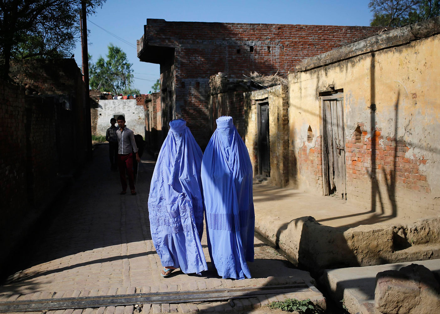 Muslim women, who were displaced by deadly religious strife last year, walk back to their relief camp after casting their vote for the general election at a polling station in Palra village in Muzaffarnagar district in the northern Indian state of Uttar Pradesh, April 10, 2014.