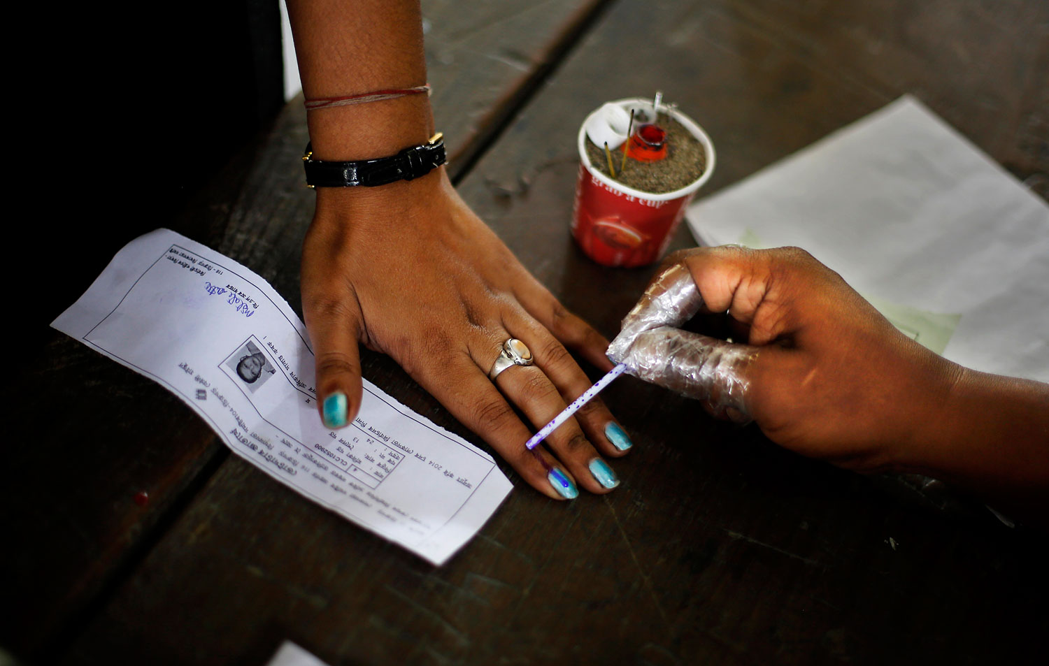 An Indian election officer applies an indelible ink mark on the finger of a woman during the first phase of elections in Dibrugarh, in the northeastern state of Assam, India, April 7, 2014.