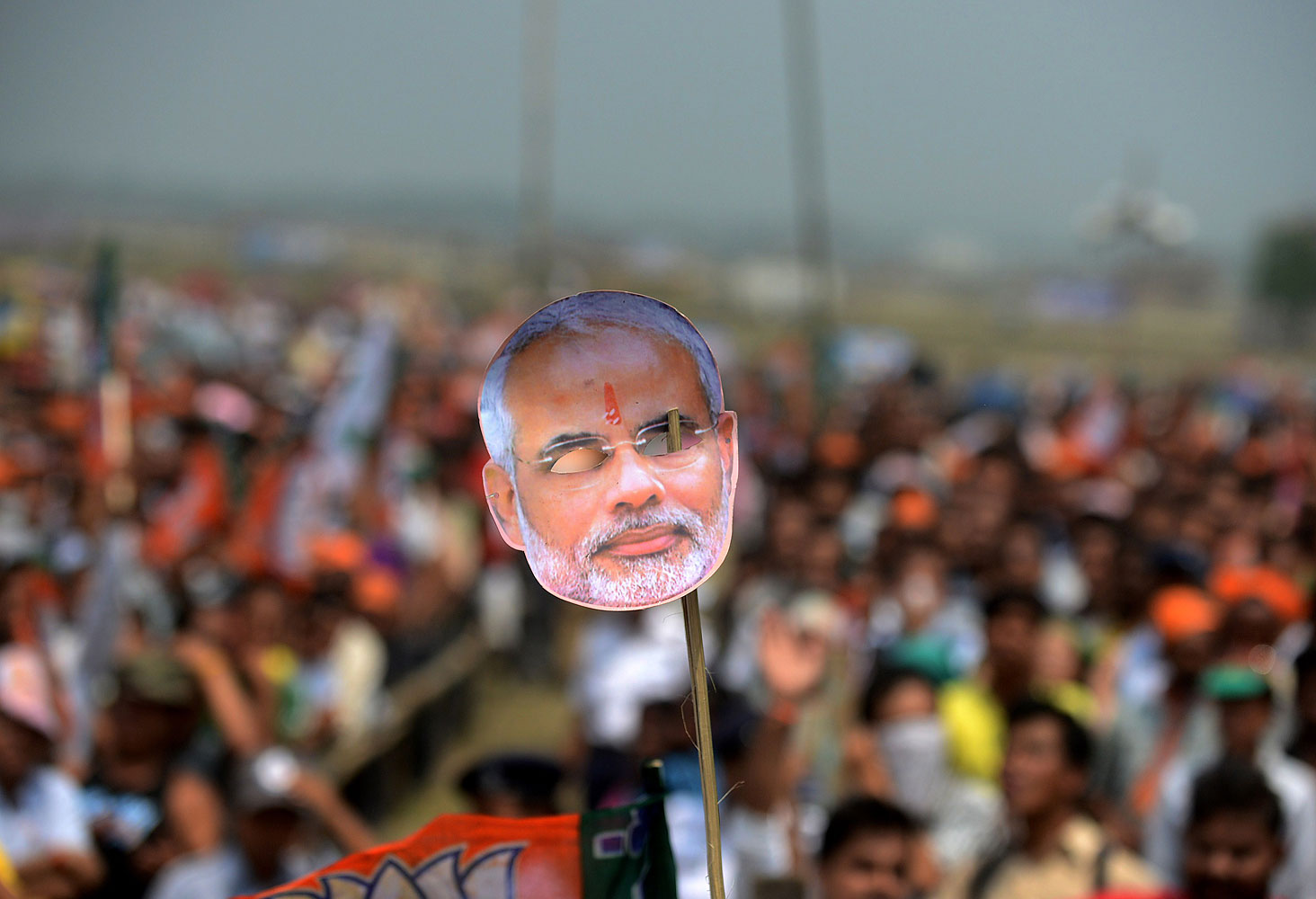 An Indian supporter holds a mask of Chief Minister of the western Gujarat state and Bharatiya Janata Party Prime Ministerial candidate, Narendra Modi during an election campaign rally for the support of BJP candidate for Darjeeling constituency, S S Ahluwalia on the outskirts of Siliguri on April 10, 2014.