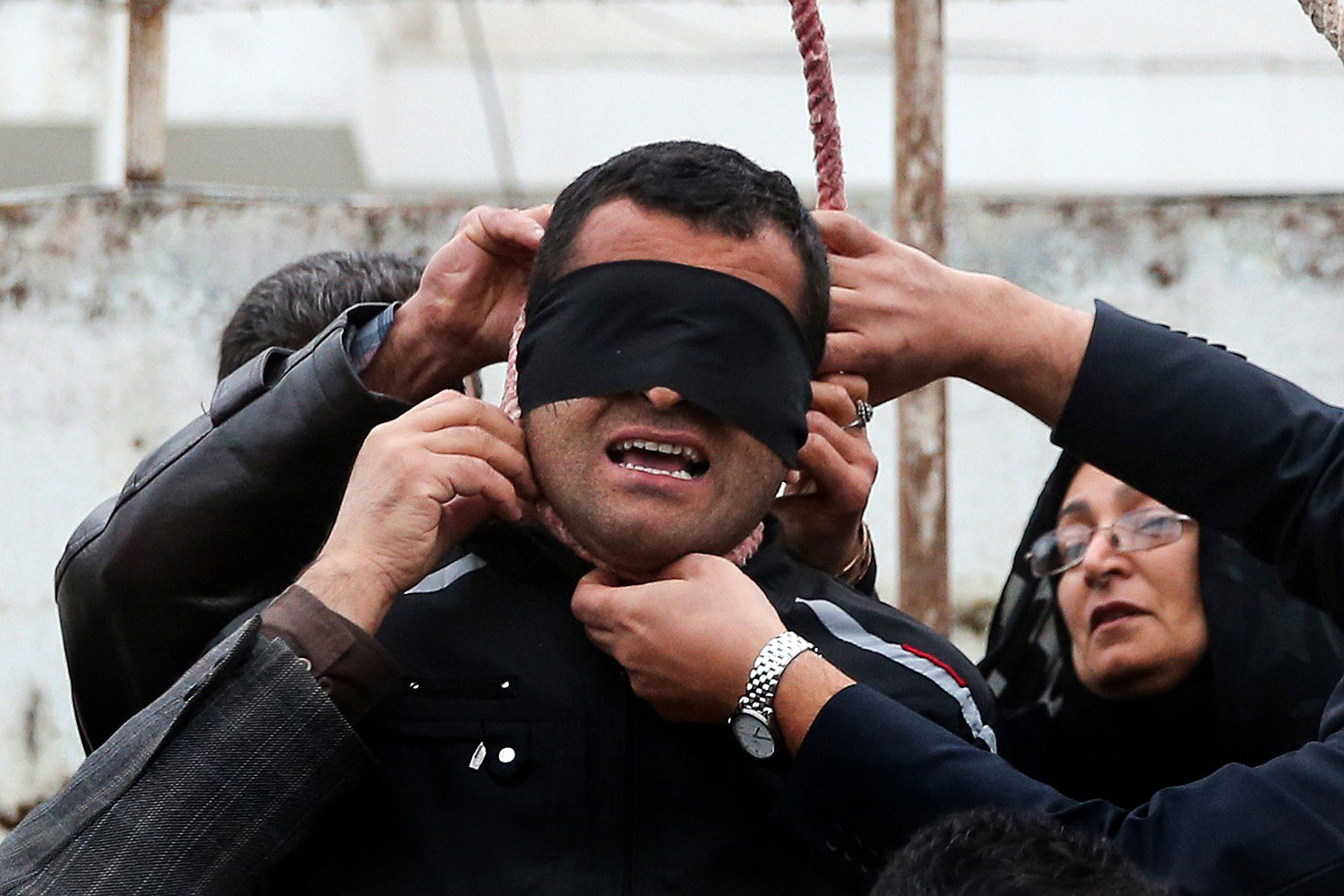 The mother of Abdolah Hosseinzadeh removes the noose with the help of her husband from around the neck of Balal, sparing the life of her son's convicted murderer, April 15, 2014.