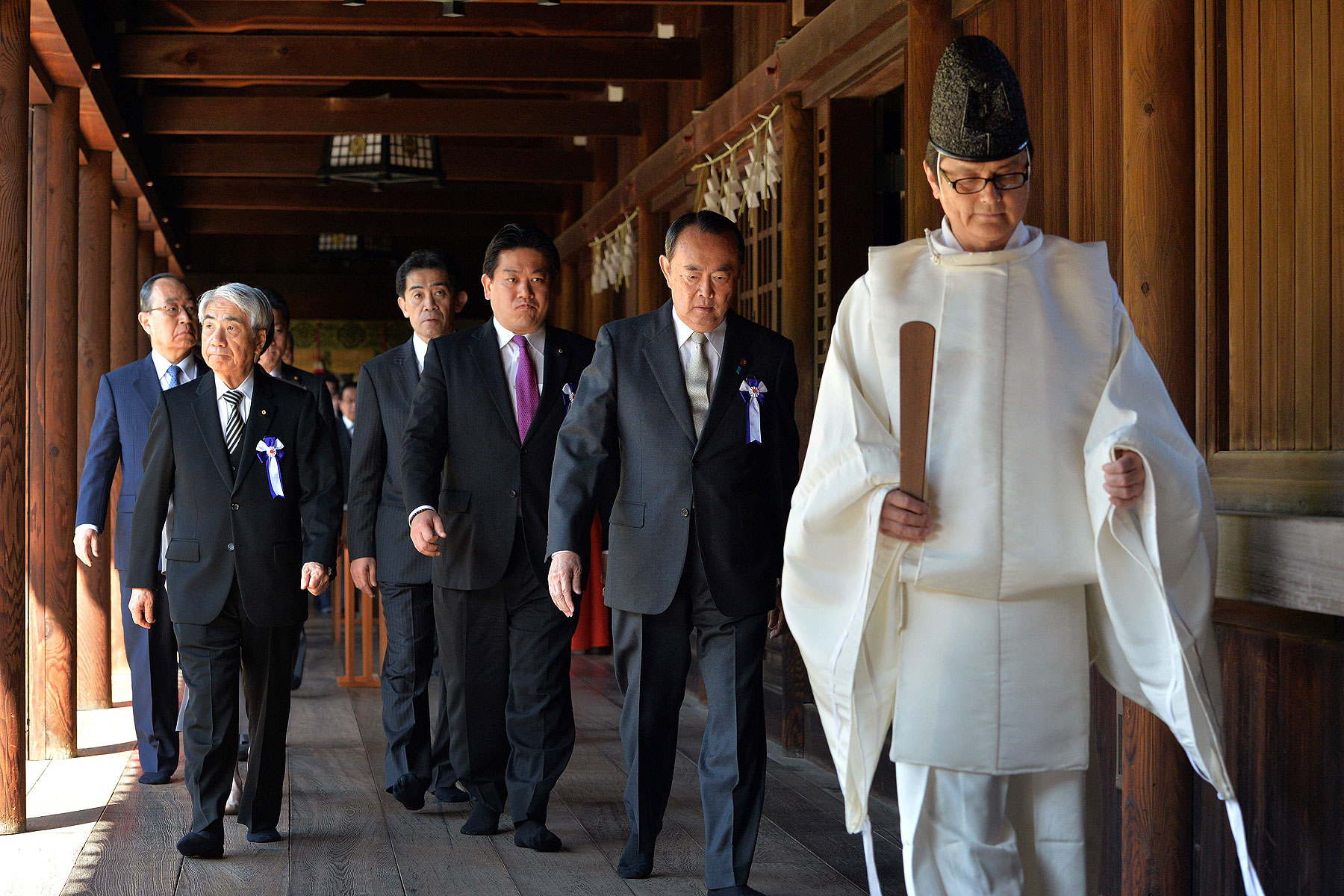 Japanese lawmakers follow a Shinto priest during a visit to the controversial Yasukuni Shrine to honor war dead during a spring festival in Tokyo on April 22, 2014 (Yoshikazu Tsuno—AFP/Getty Images)