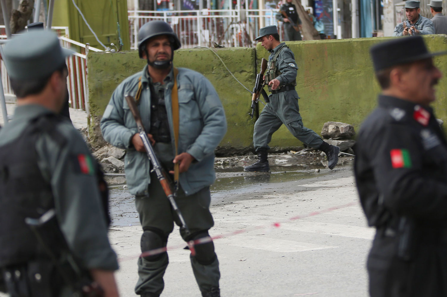 Afghan police men block the street after a suicide bomber wearing a military uniform struck the entrance gate of the Interior Ministry compound in Kabul, April 2, 2014.